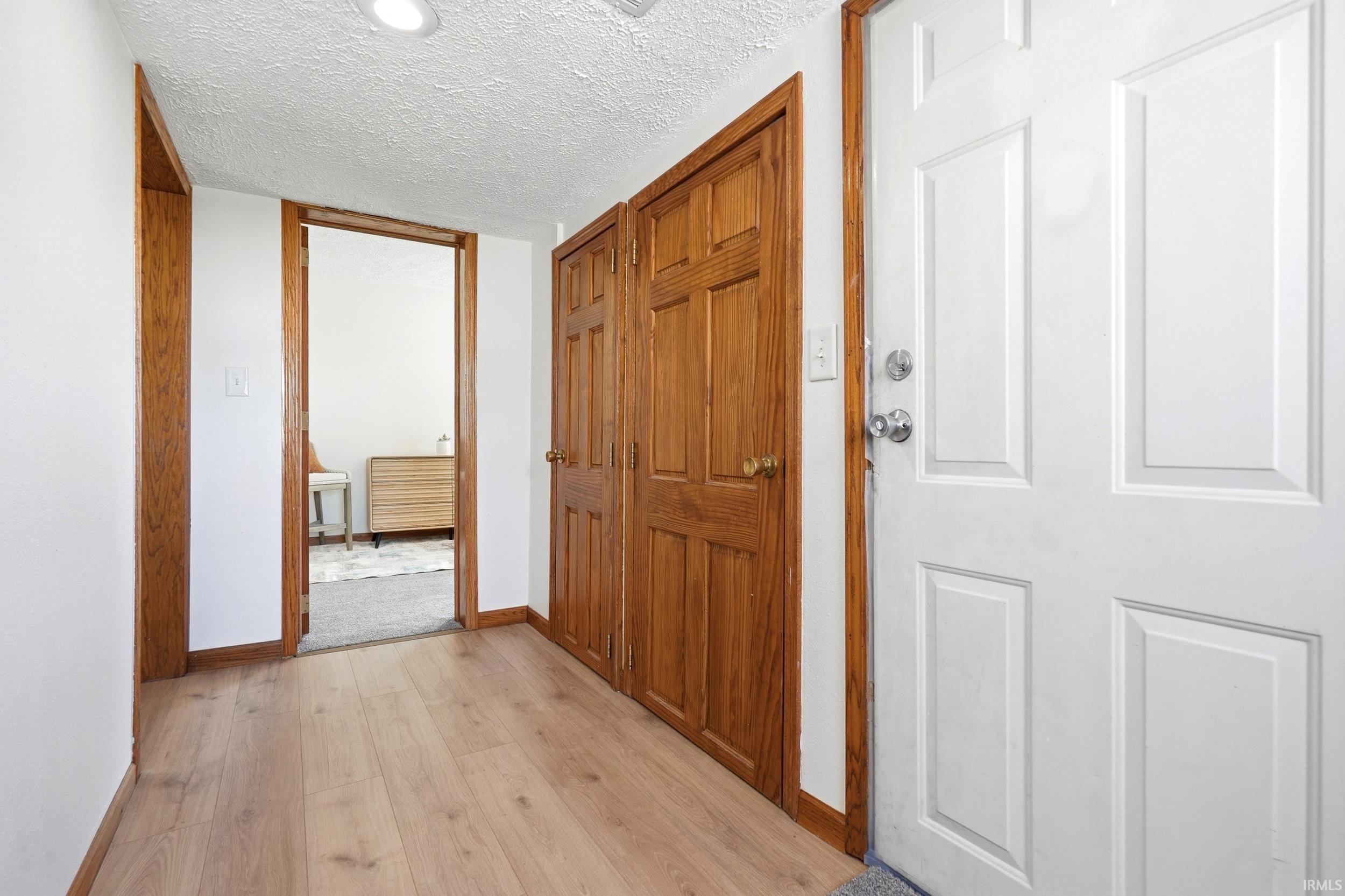 Entryway featuring light wood-finish flooring, white walls, and recessed lighting