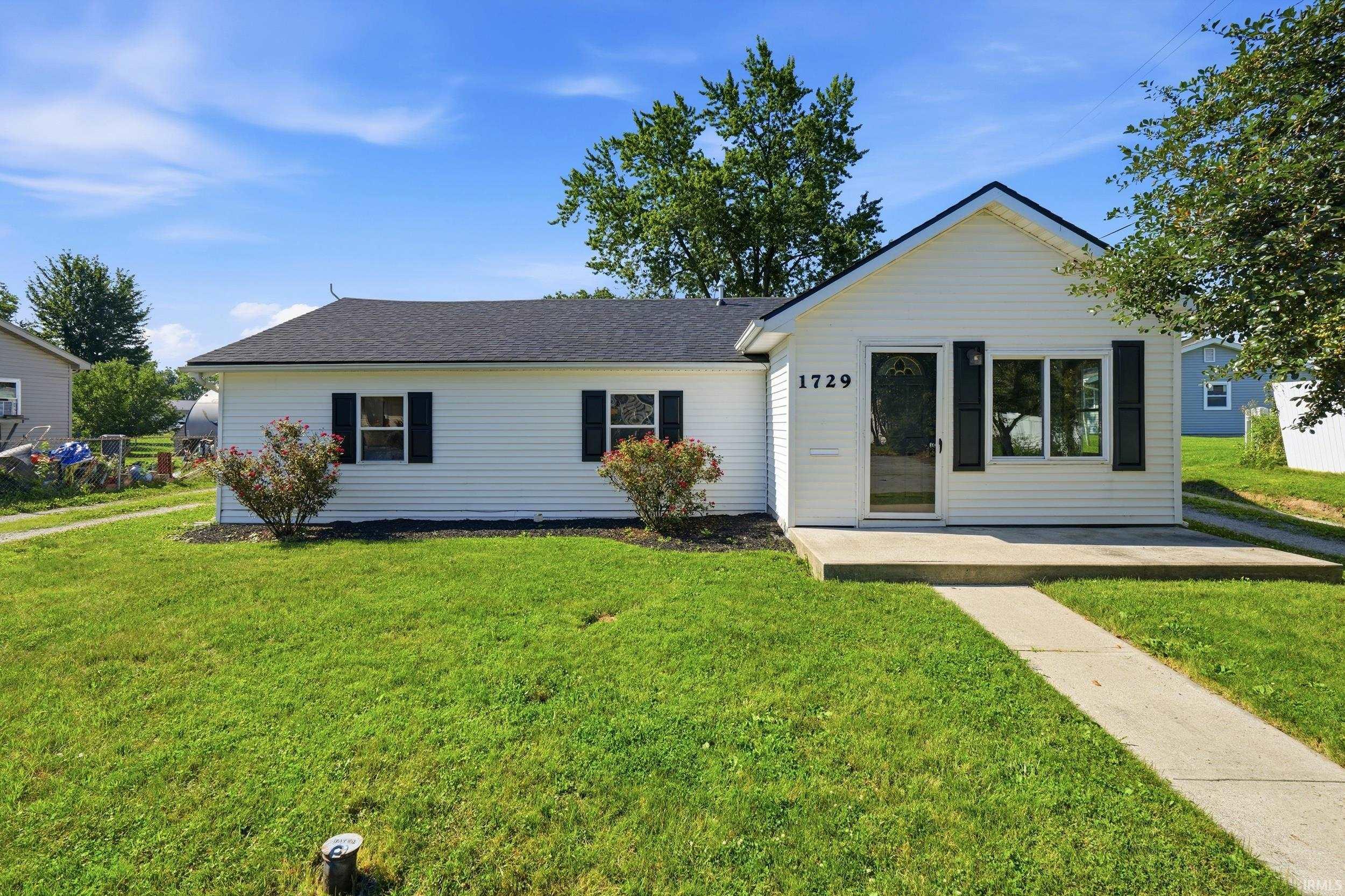 White siding exterior with a dark shingle roof, offering a concrete walkway and front patio