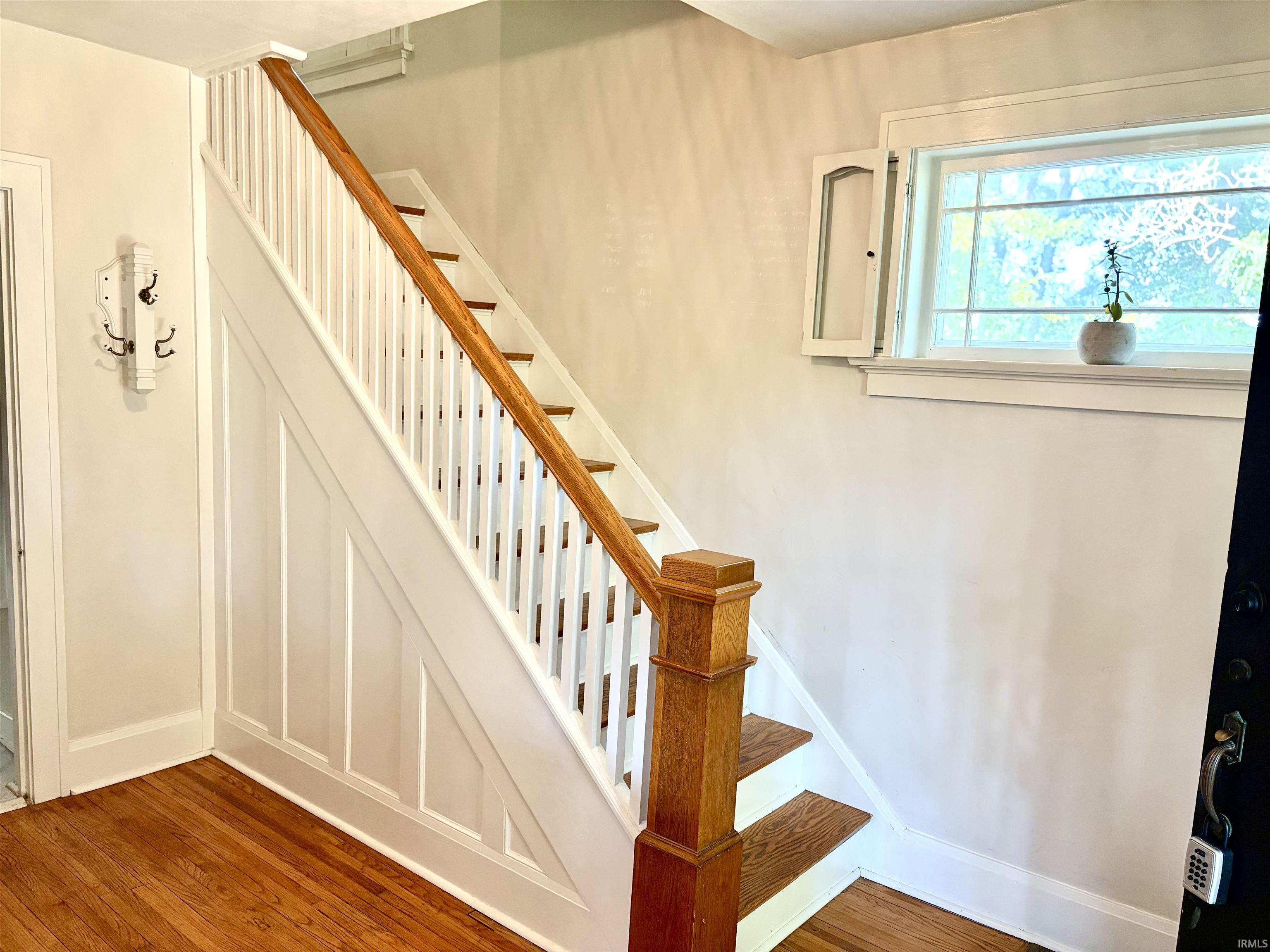 Hardwood flooring and staircase with white risers and balusters
