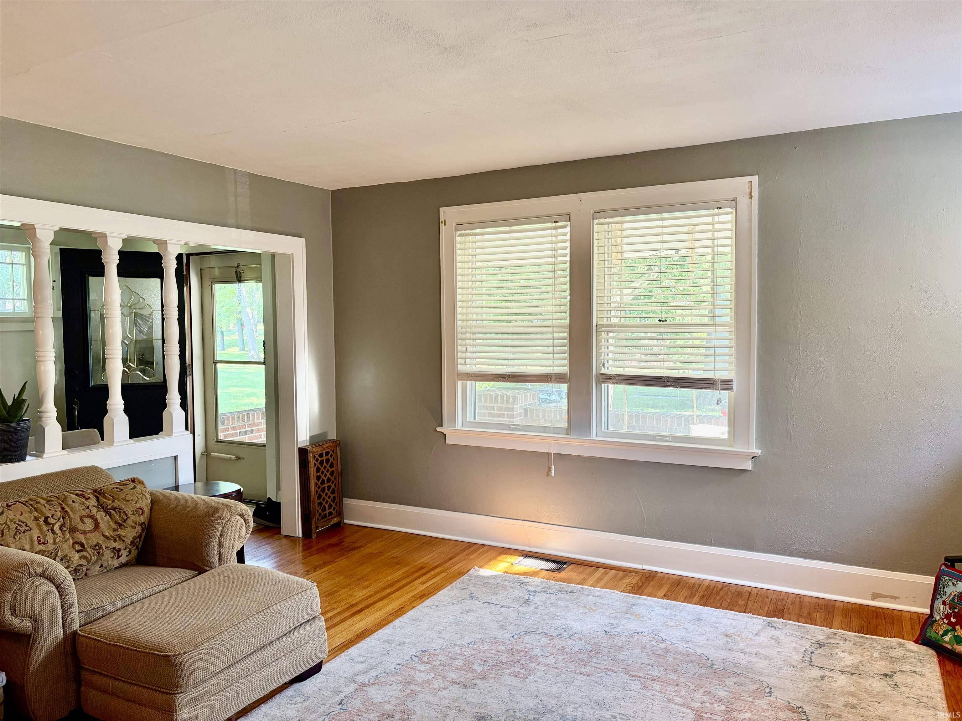 Interior space featuring wood-finish flooring, white baseboards, and neutral wall paint