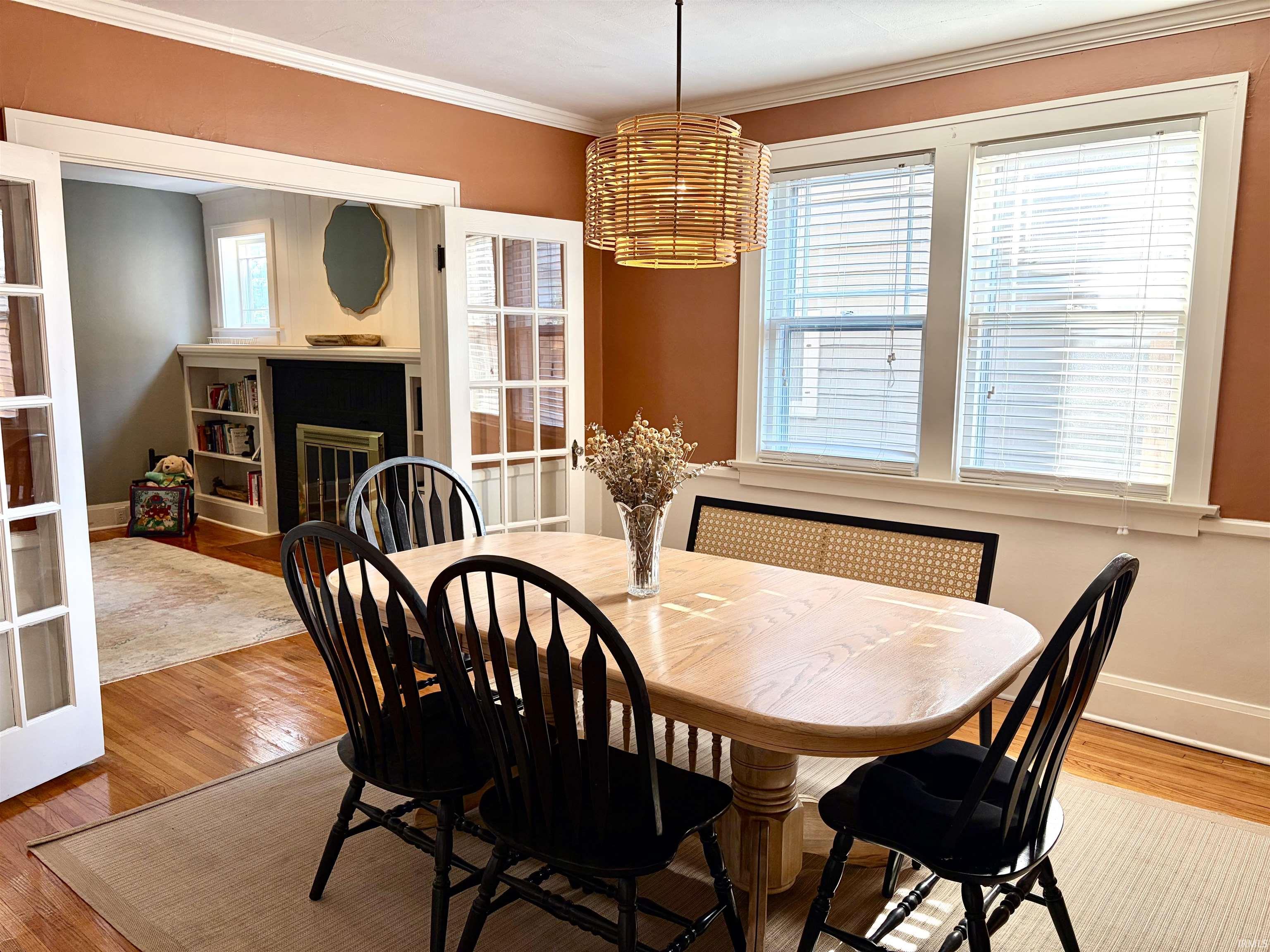 Dining area featuring wood-finish flooring and a contemporary woven pendant light fixture