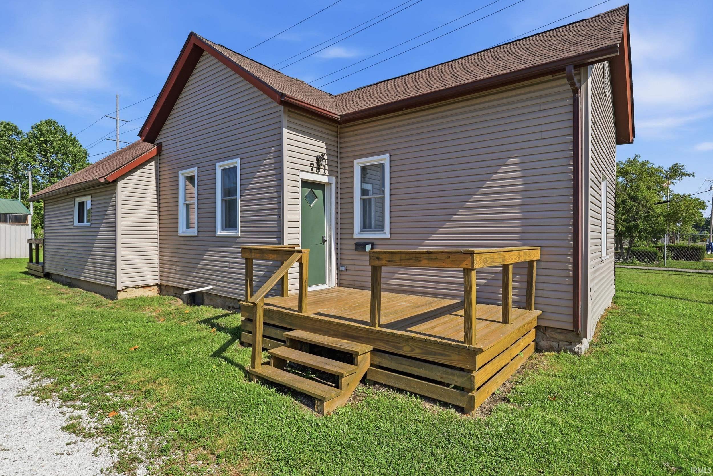 Exterior featuring beige vinyl siding, a brown shingle roof, and white trim