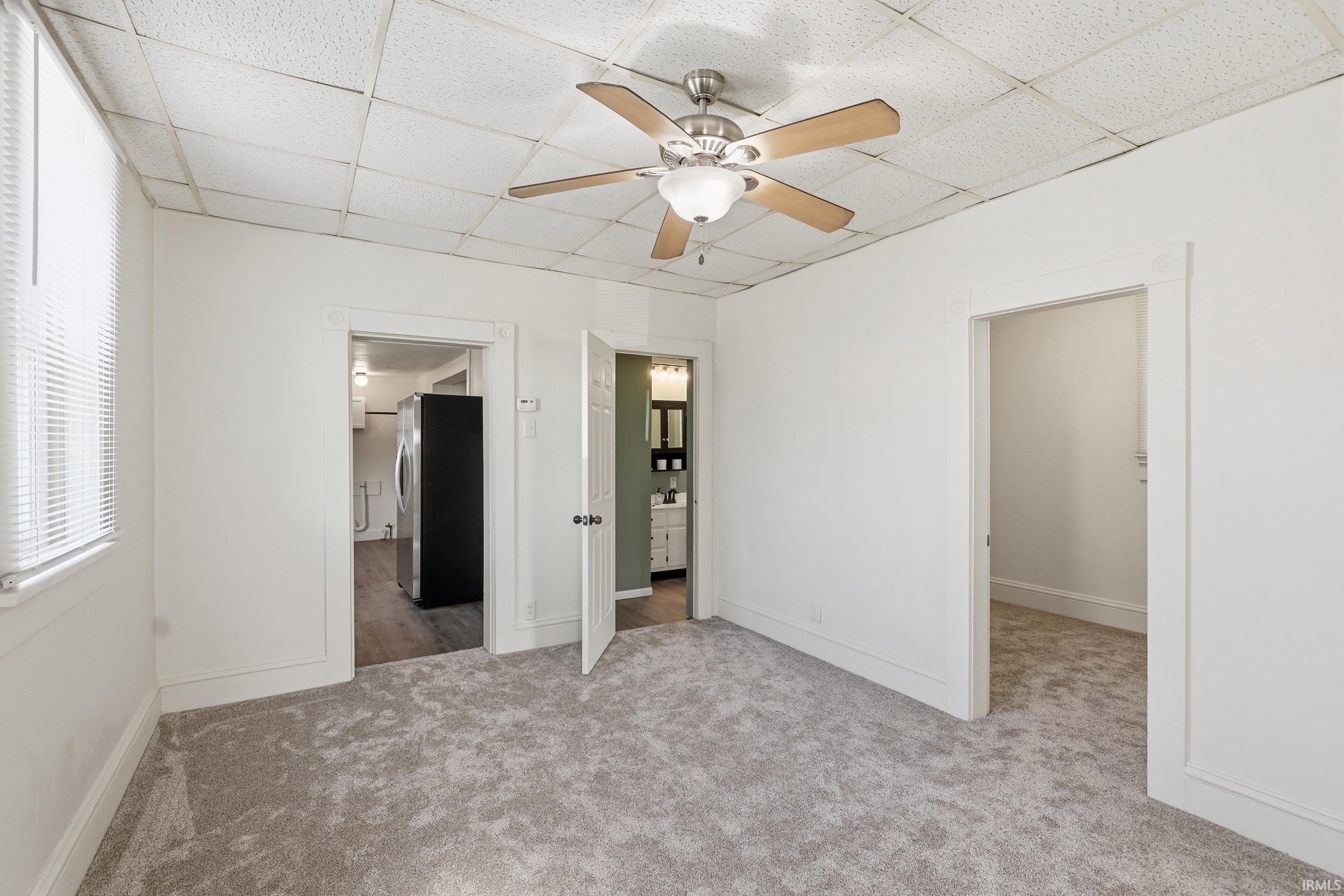 Neutral tone carpeting with white baseboards and trim