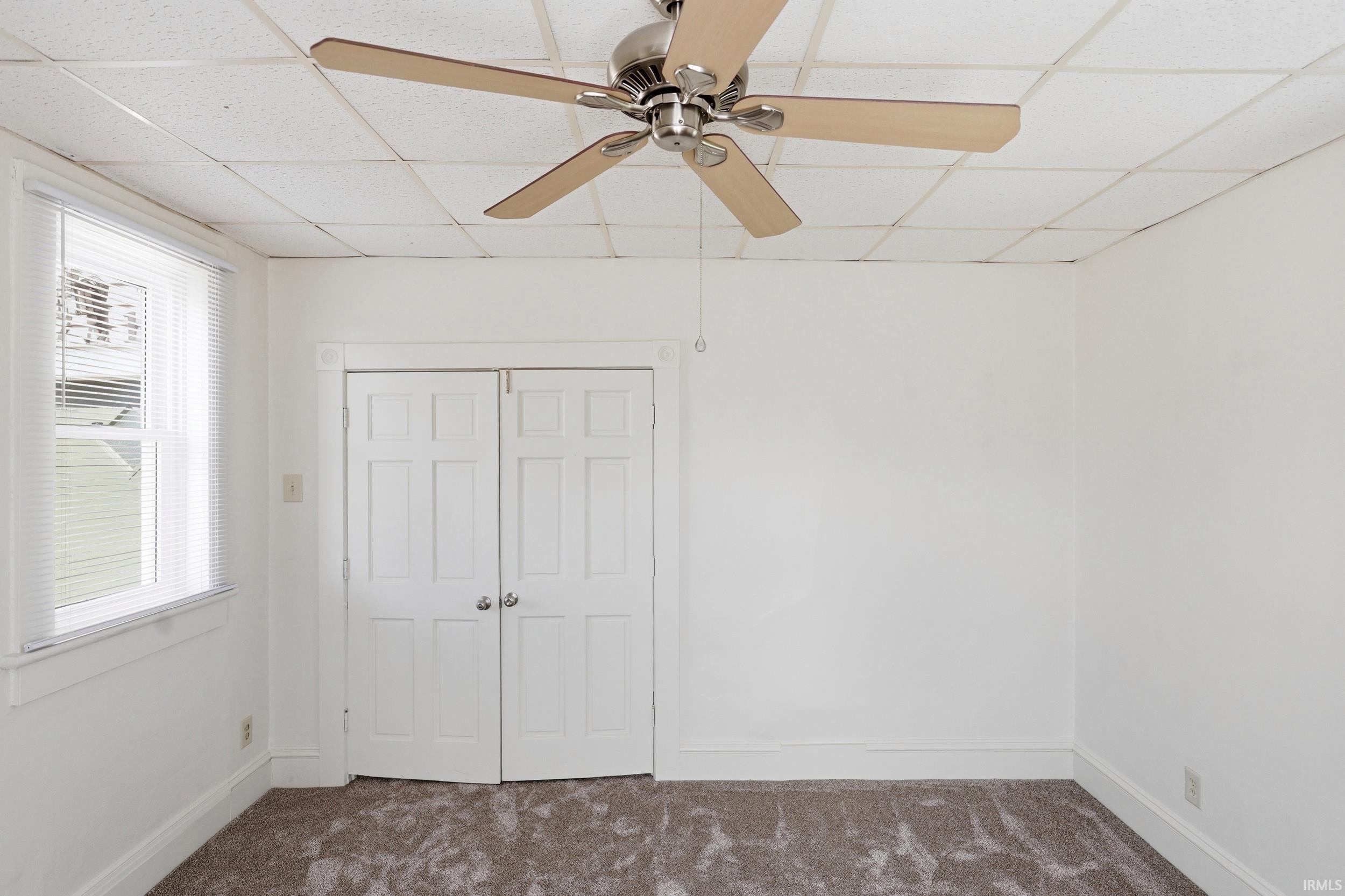 Neutral-toned wall-to-wall carpeting complements the white walls and trim