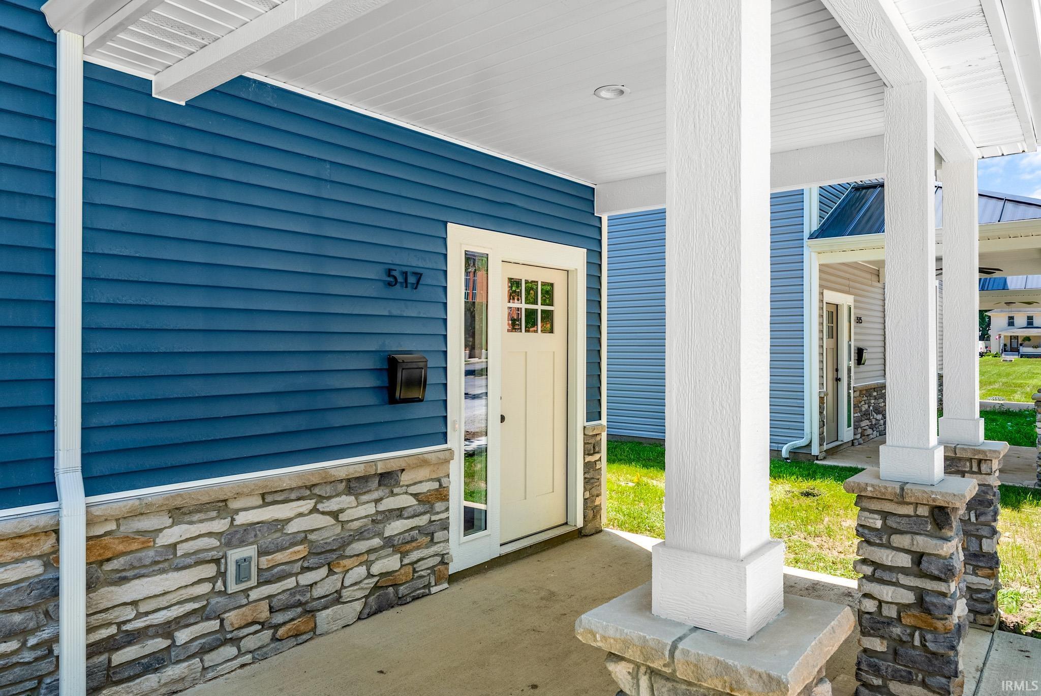 Front entry featuring a cream-colored door with multi-pane window inserts