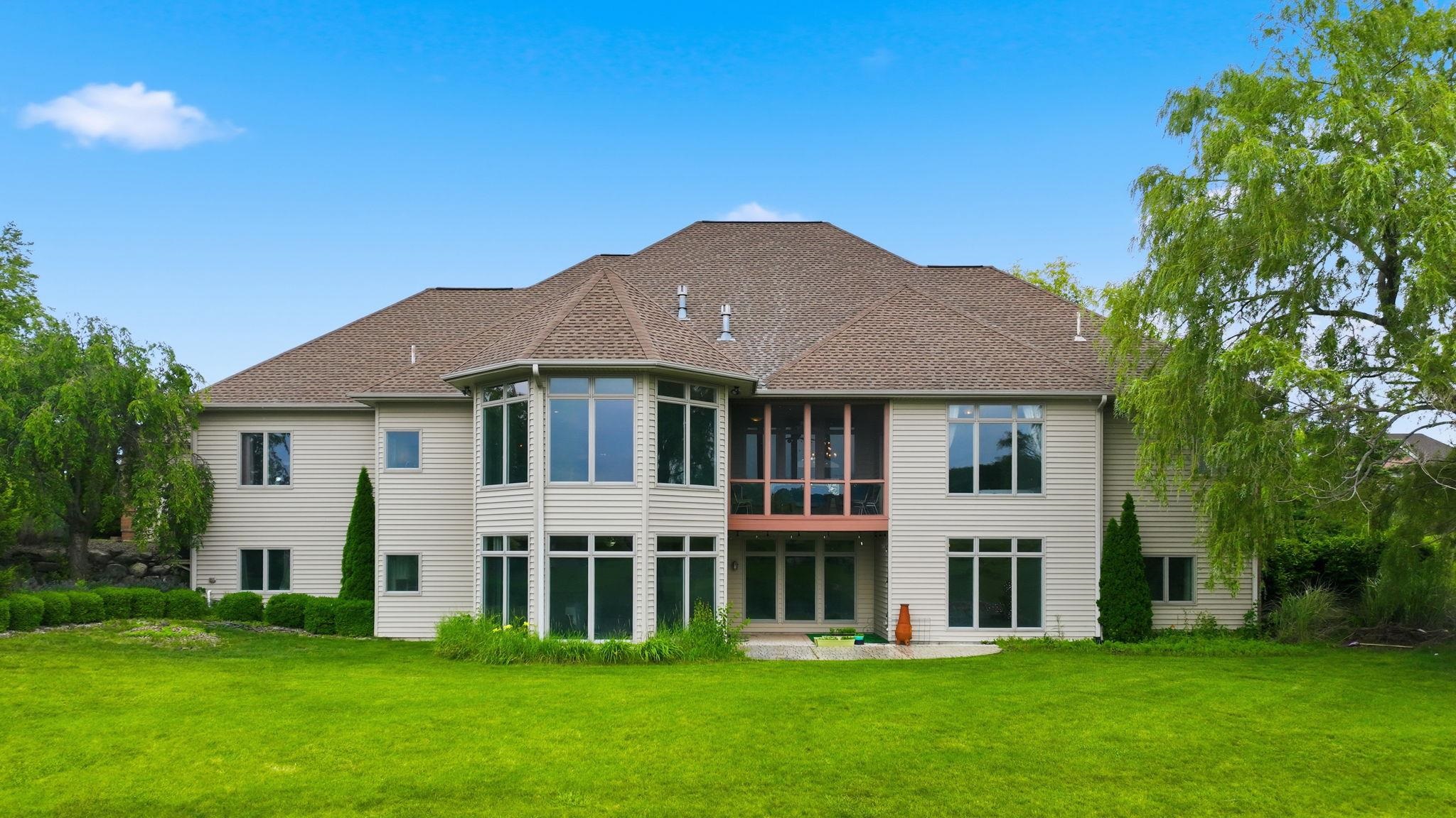 Expansive rear exterior featuring a multi-level design, a prominent bay window structure, and a screened-in porch