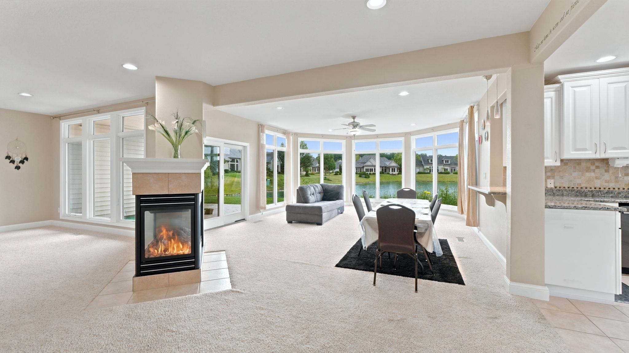 Open-concept living space featuring a central fireplace with a tiled surround