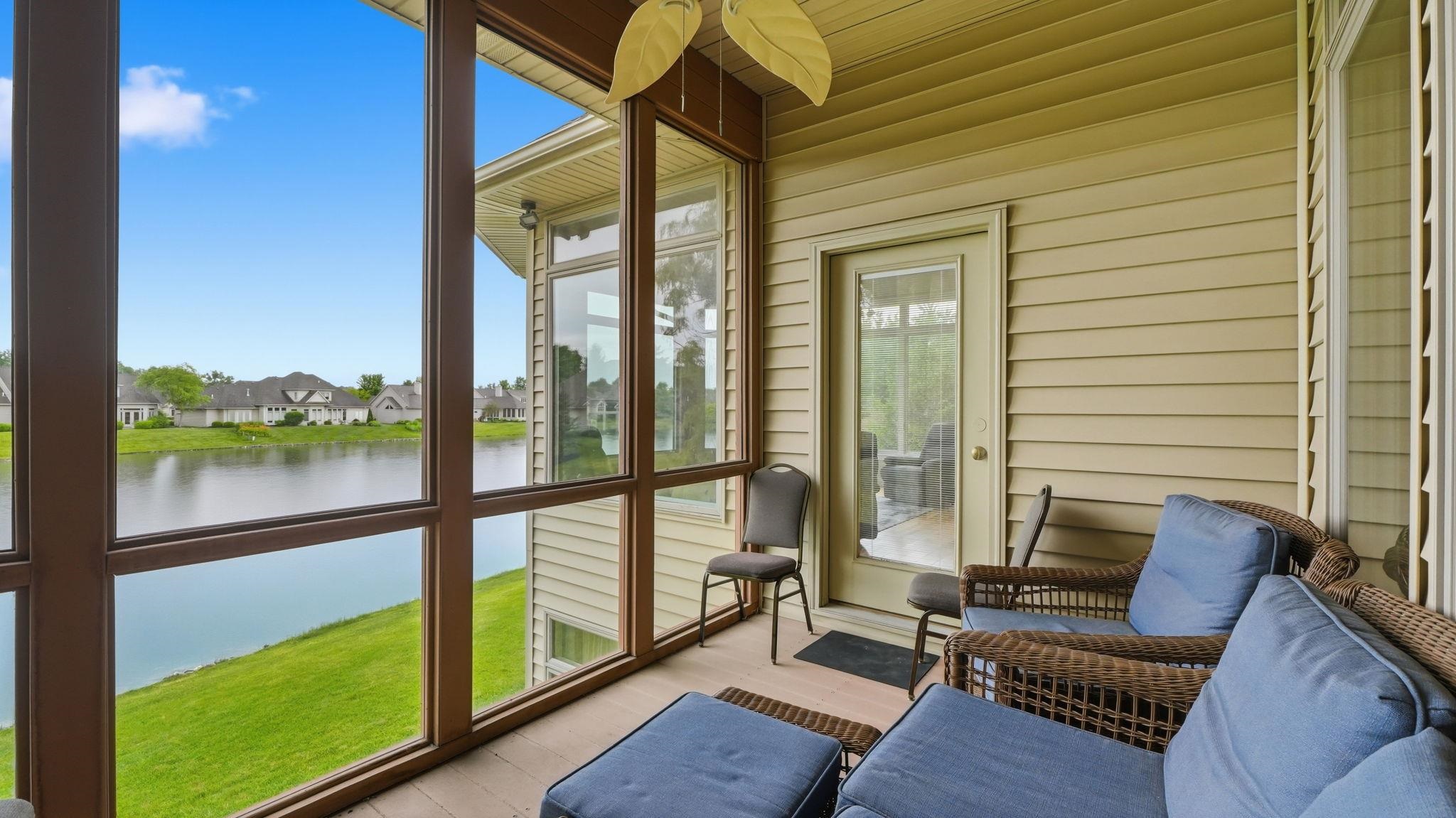 Screened porch featuring extensive glass panels, a ceiling fan, and a light-colored siding exterior