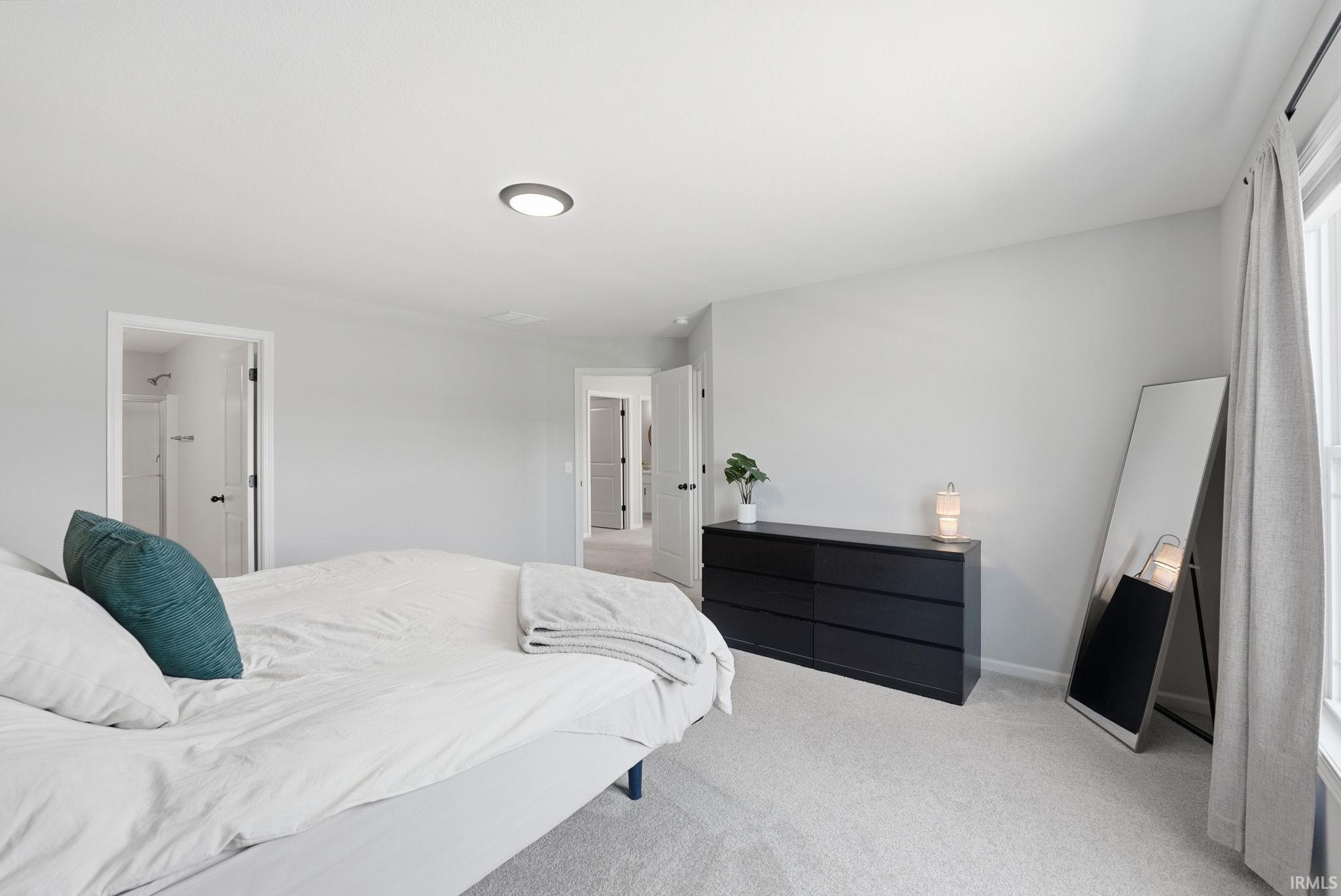 Carpeted bedroom featuring light gray walls, a recessed ceiling light, and white trim