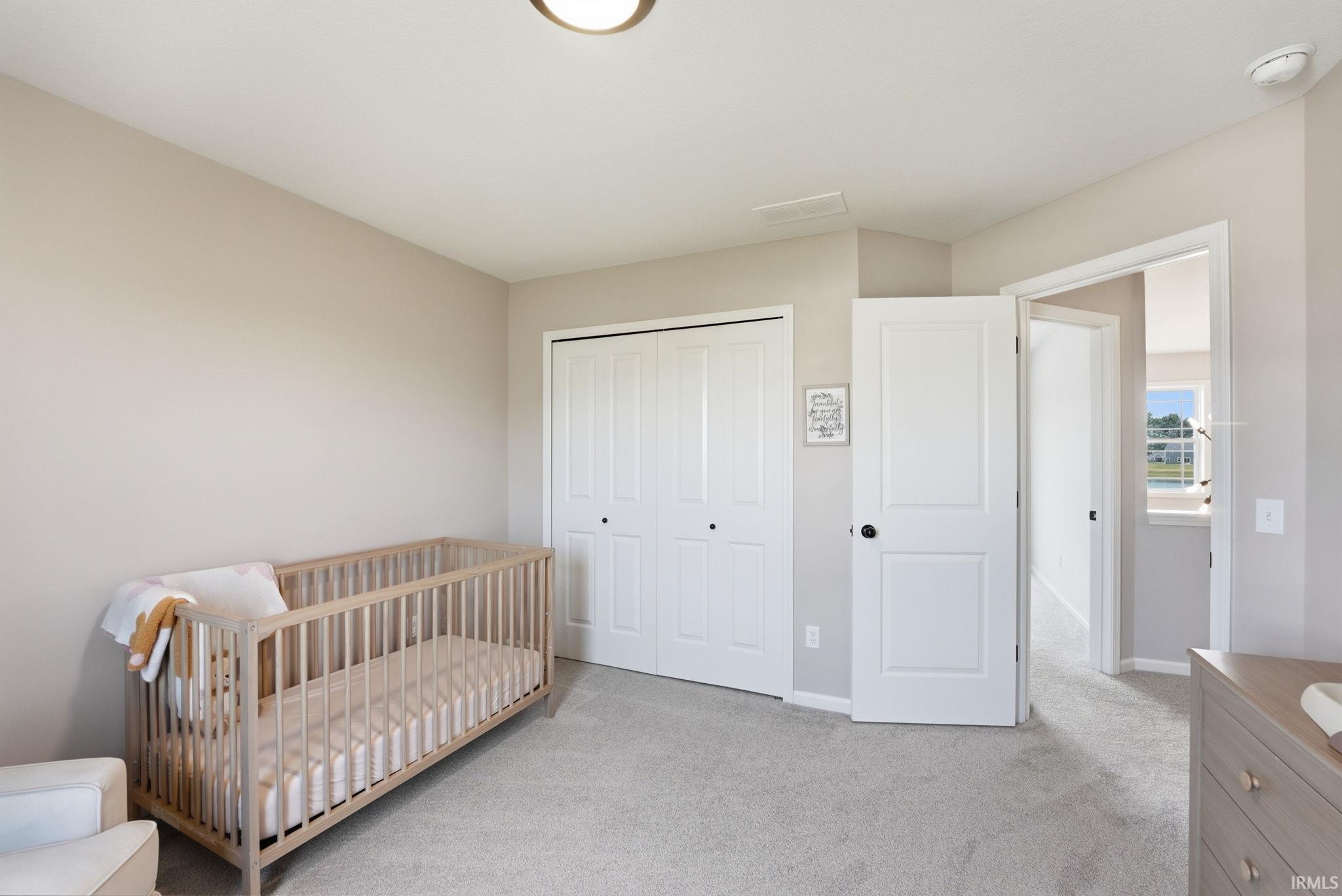 Carpeted room with a ceiling-mounted light fixture, neutral wall paint, and white trim