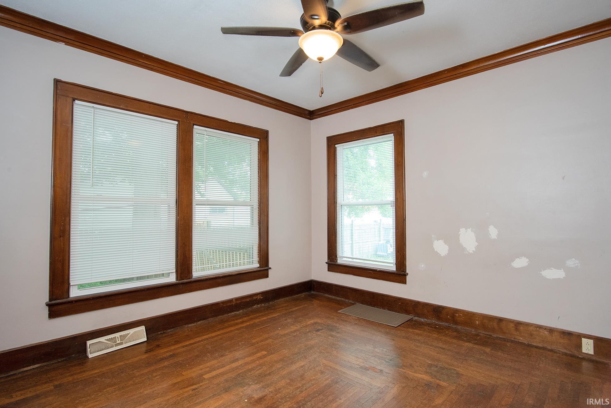Hardwood flooring complemented by dark wood trim and crown molding