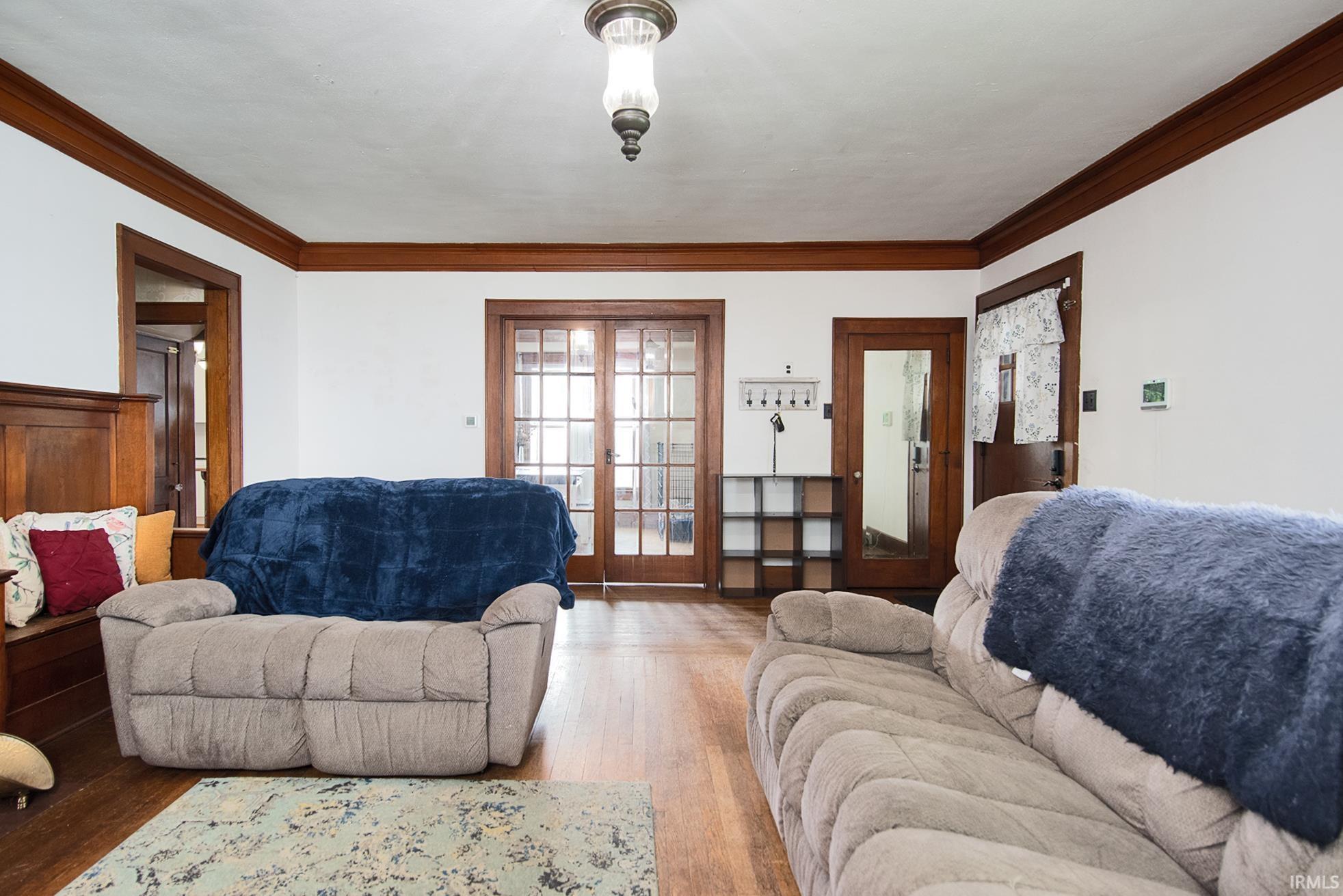 Hardwood flooring extends throughout this room, complemented by white walls and dark wood trim