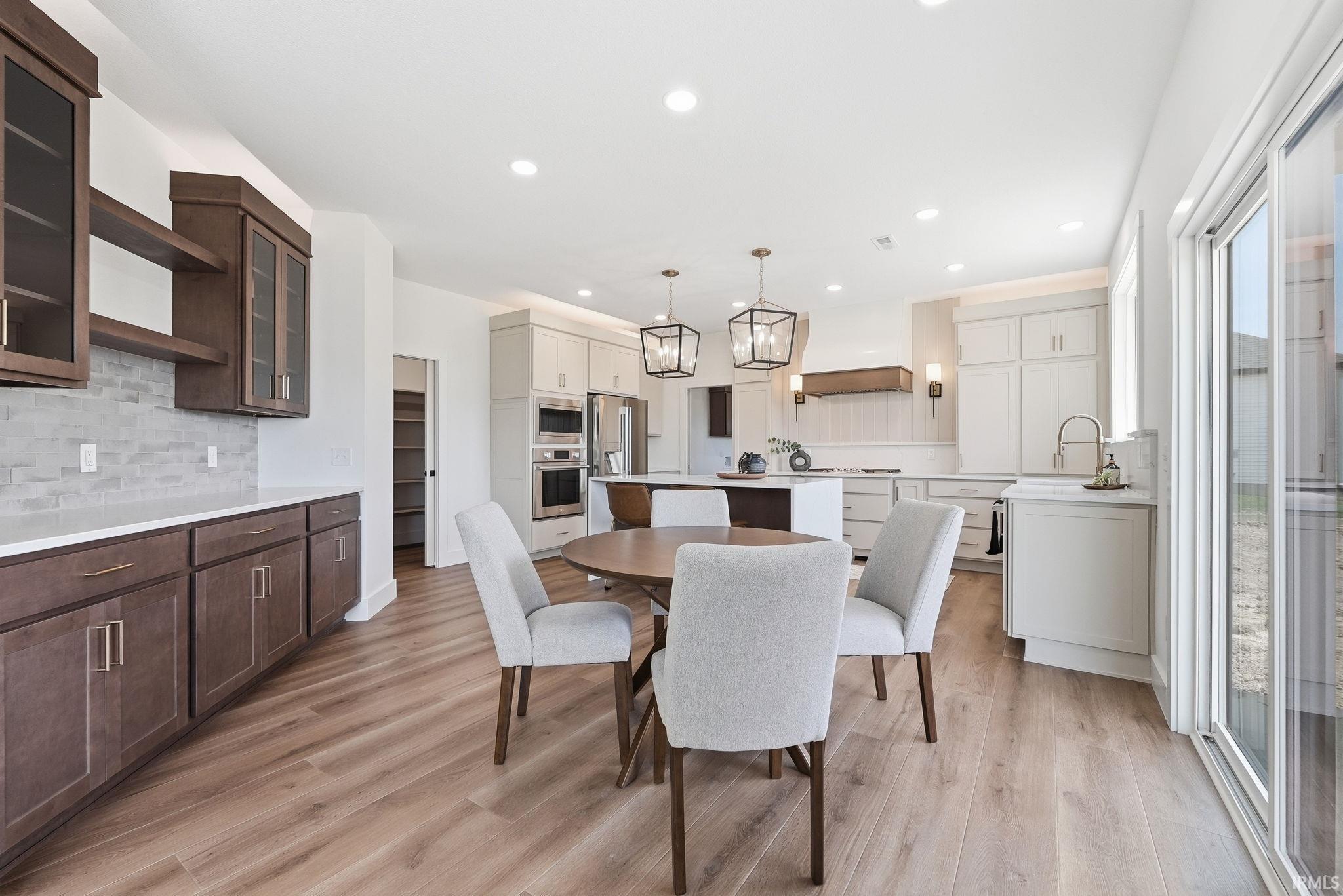Open-concept kitchen with wood-finish flooring, recessed lighting, and a kitchen island with pendant lighting