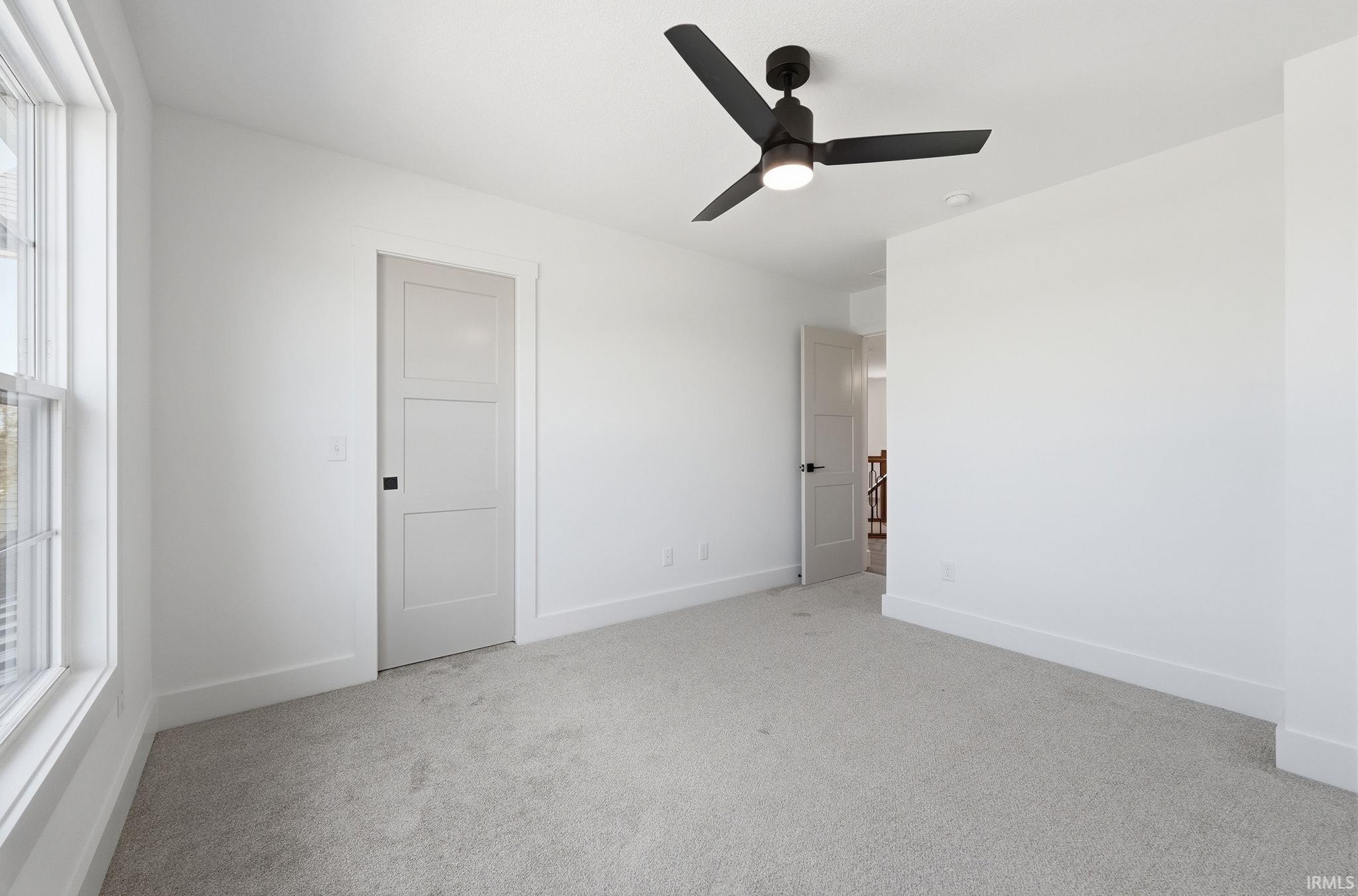 Neutral tone-on-tone carpet flooring complements the white walls and trim