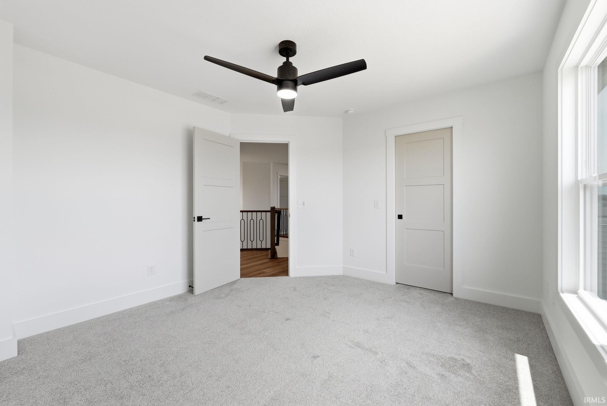 Neutral-toned carpeting complements bright white walls and trim