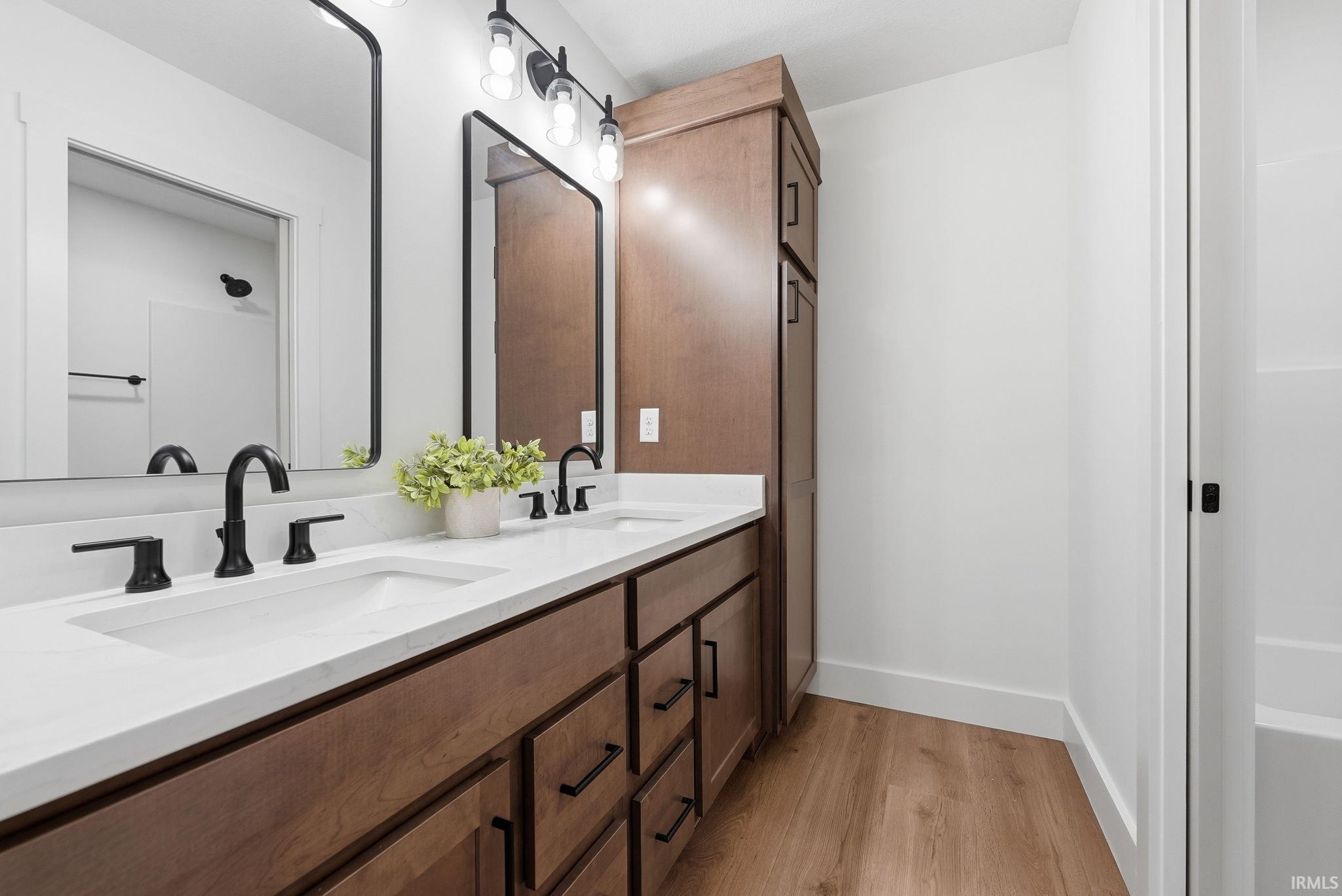 Bathroom featuring a double vanity with white countertops, integrated sinks, and matte black fixtures
