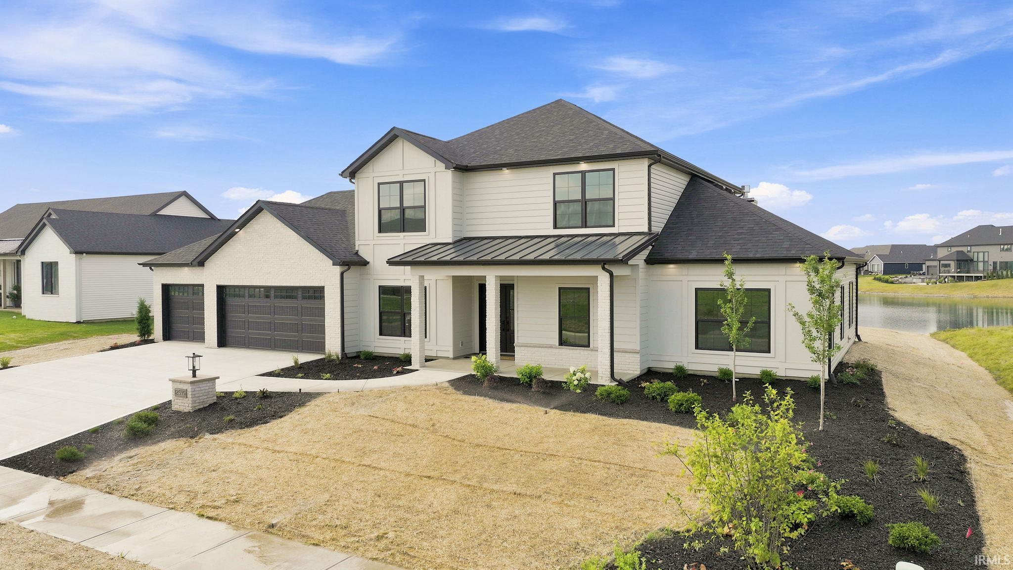 Modern farmhouse-style residence featuring white siding and dark trim