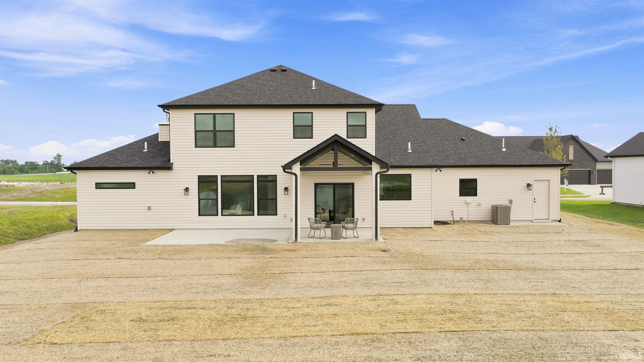 Rear exterior featuring white horizontal siding and a dark shingle roof