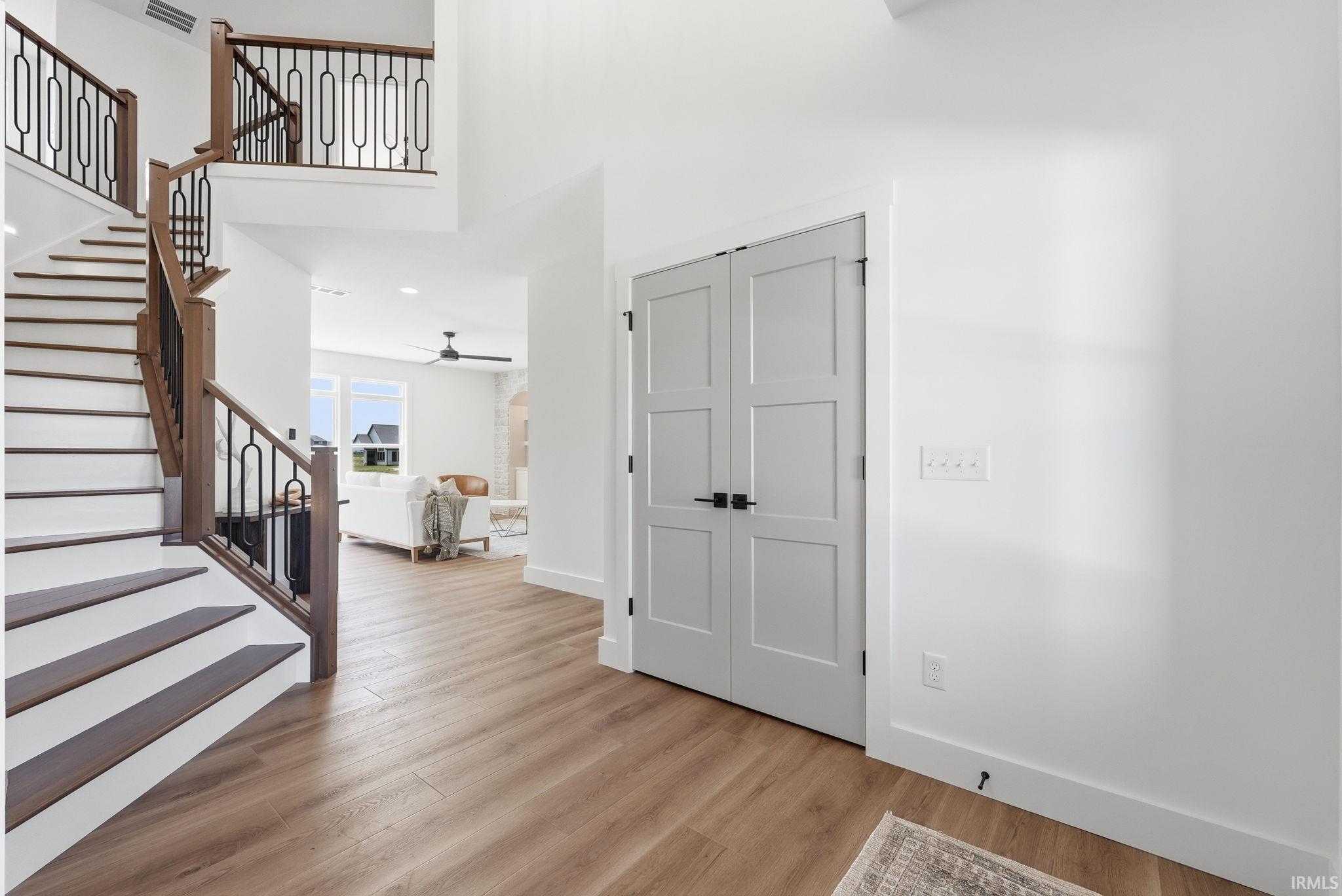 Grand entryway featuring a two-story staircase with dark wood-finish treads and balusters