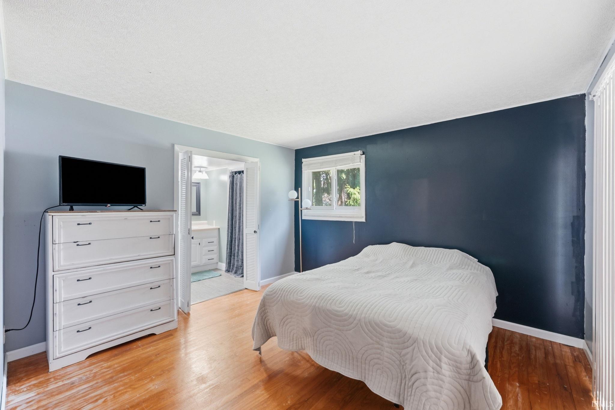 Hardwood-finish flooring throughout, complemented by a window and a neutral-toned ceiling