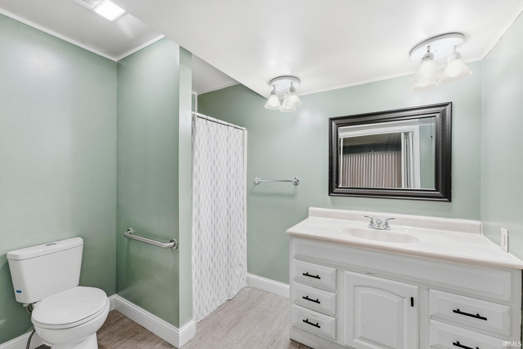 Bathroom featuring a white vanity with an integrated sink, framed mirror, and two wall-mounted light fixtures