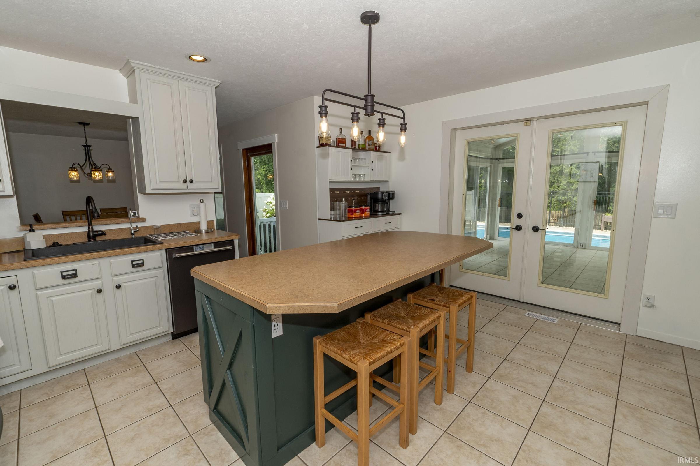 Kitchen featuring a central island with X-detail paneling, light countertop, and an industrial-style chandelier