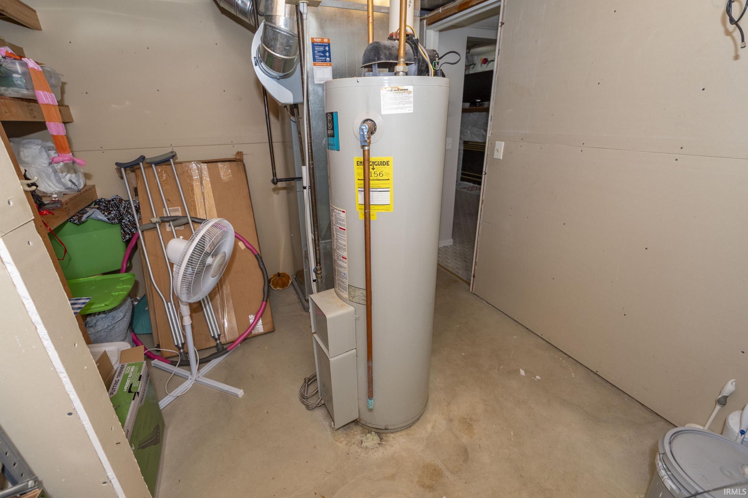 Water heater with visible energy guide label, copper piping, and metal ductwork