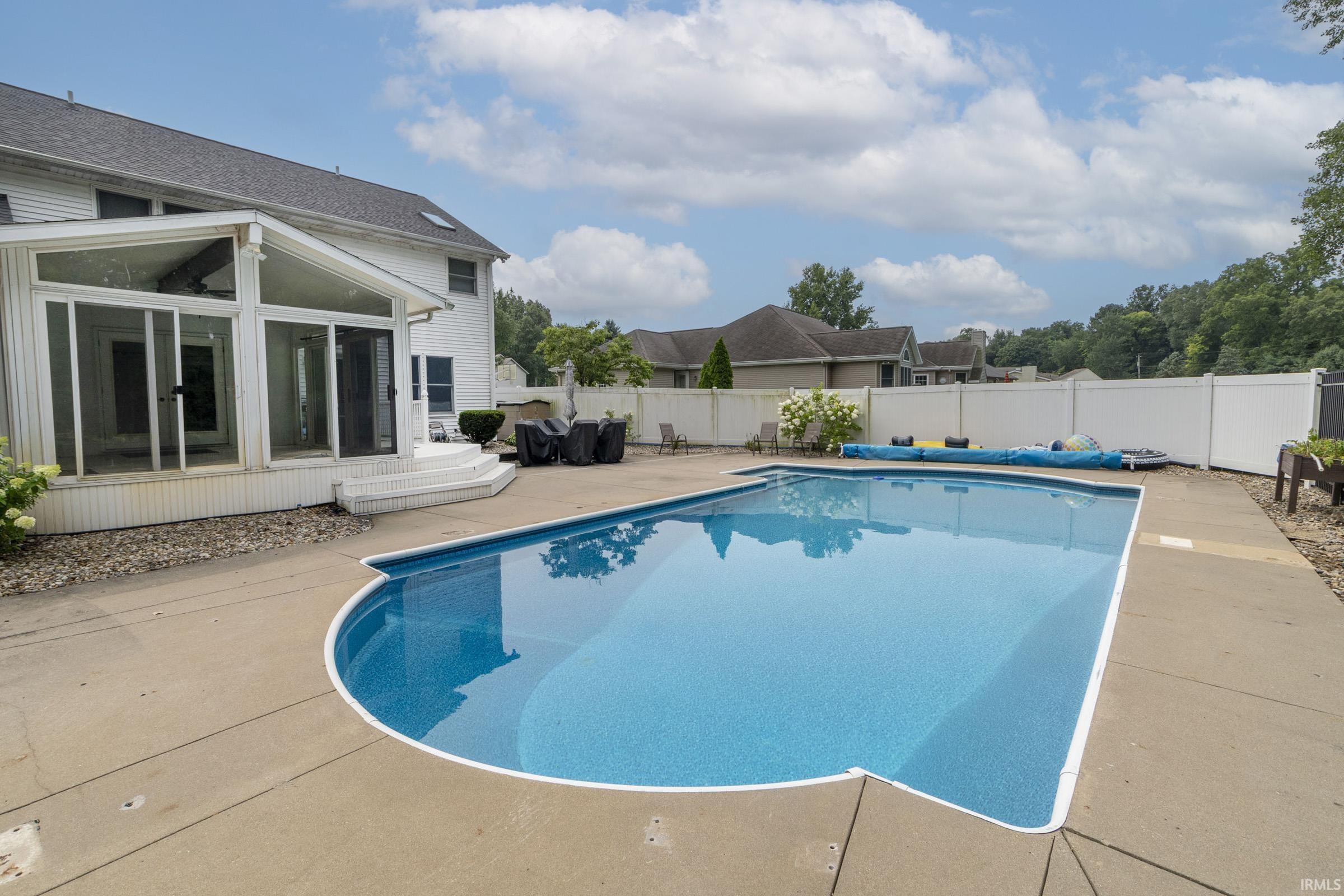 Backyard oasis featuring an in-ground swimming pool with concrete surround