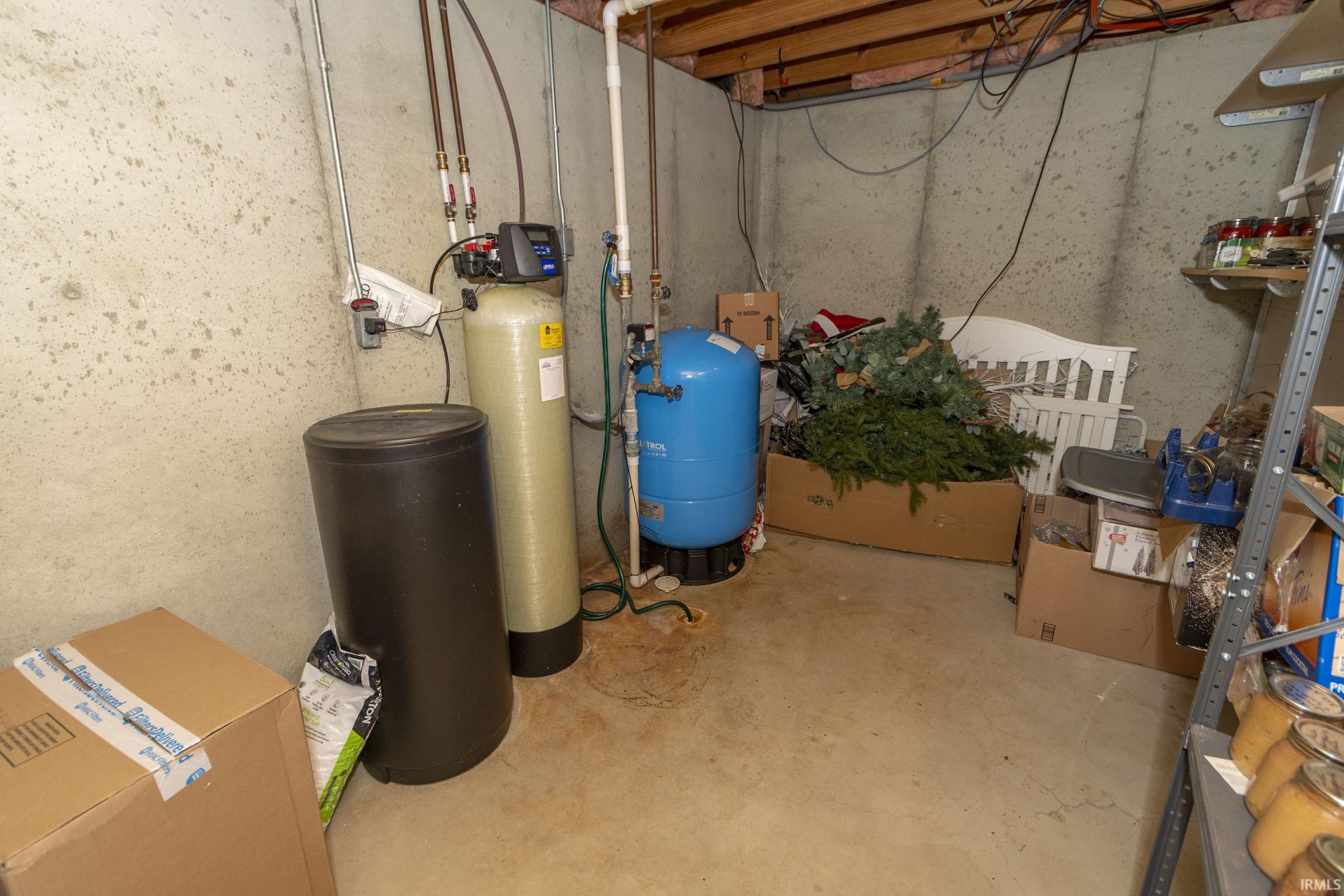 Utility room featuring a water softener system and water pressure tank