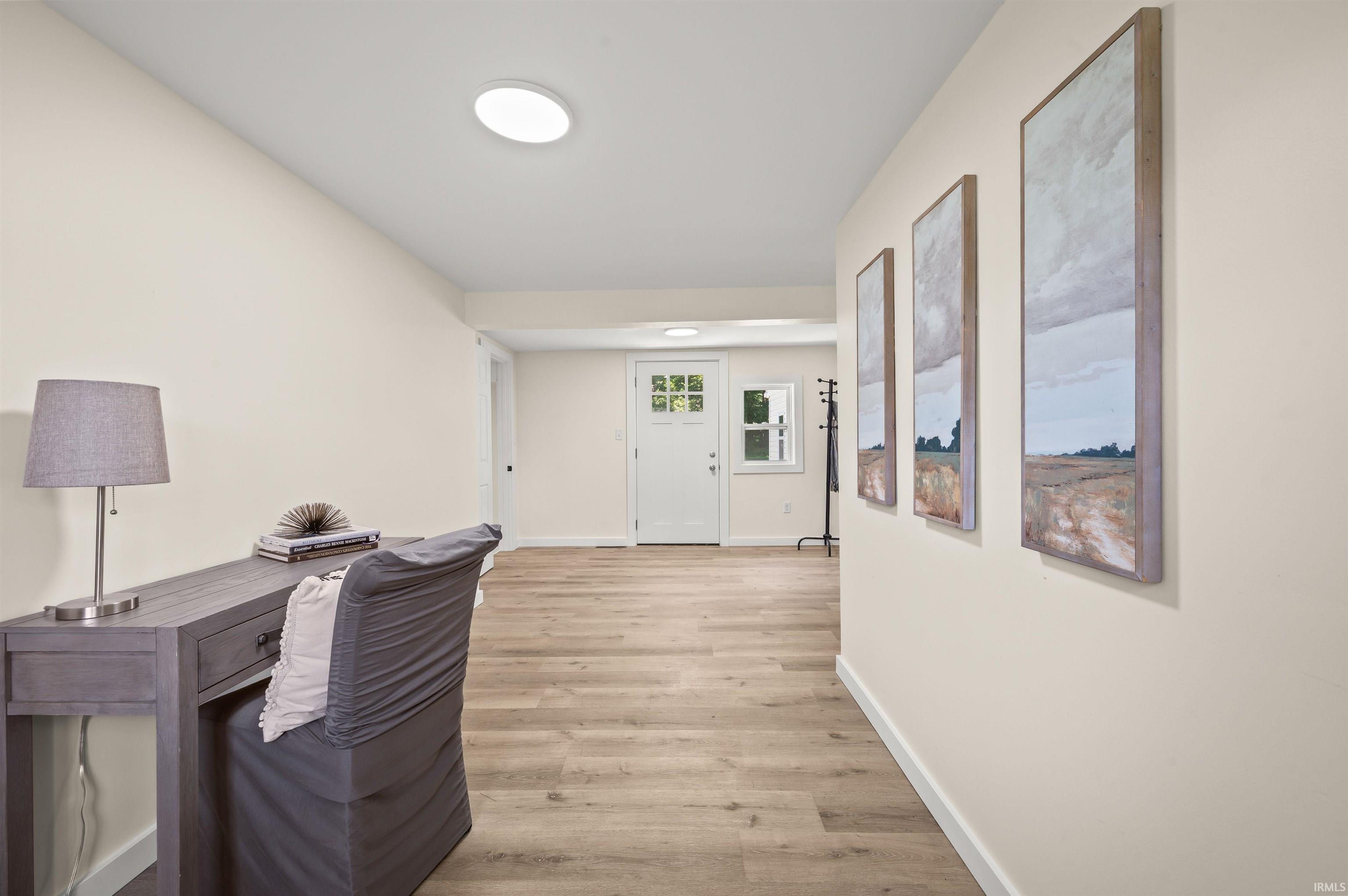 Entryway featuring wood-finish flooring, recessed lighting, and a white paneled door with glass inserts