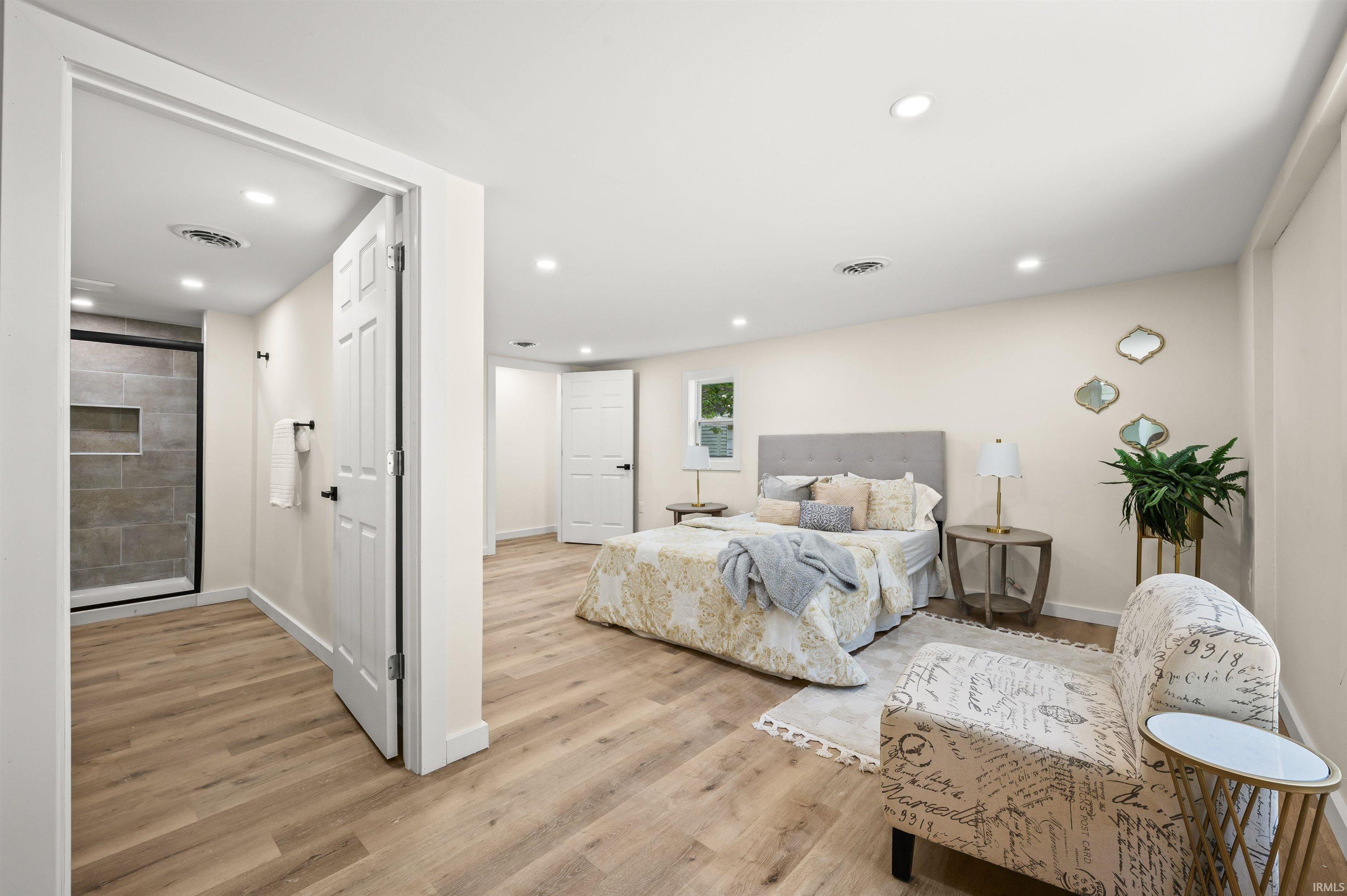 Spacious room featuring light wood-finish flooring, recessed lighting, and a neutral wall palette