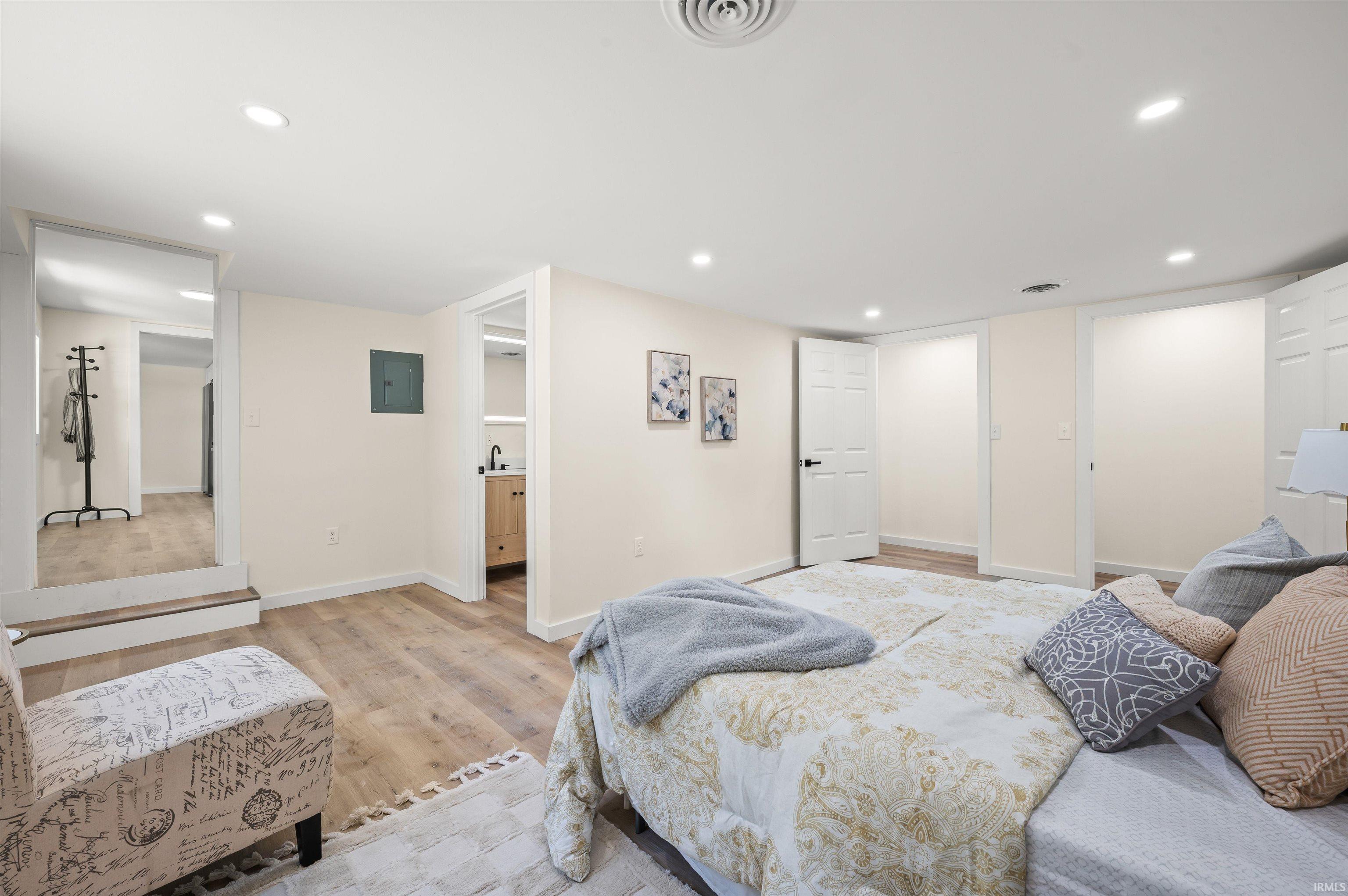 Spacious room featuring wood-finish flooring, recessed lighting, and crisp white trim
