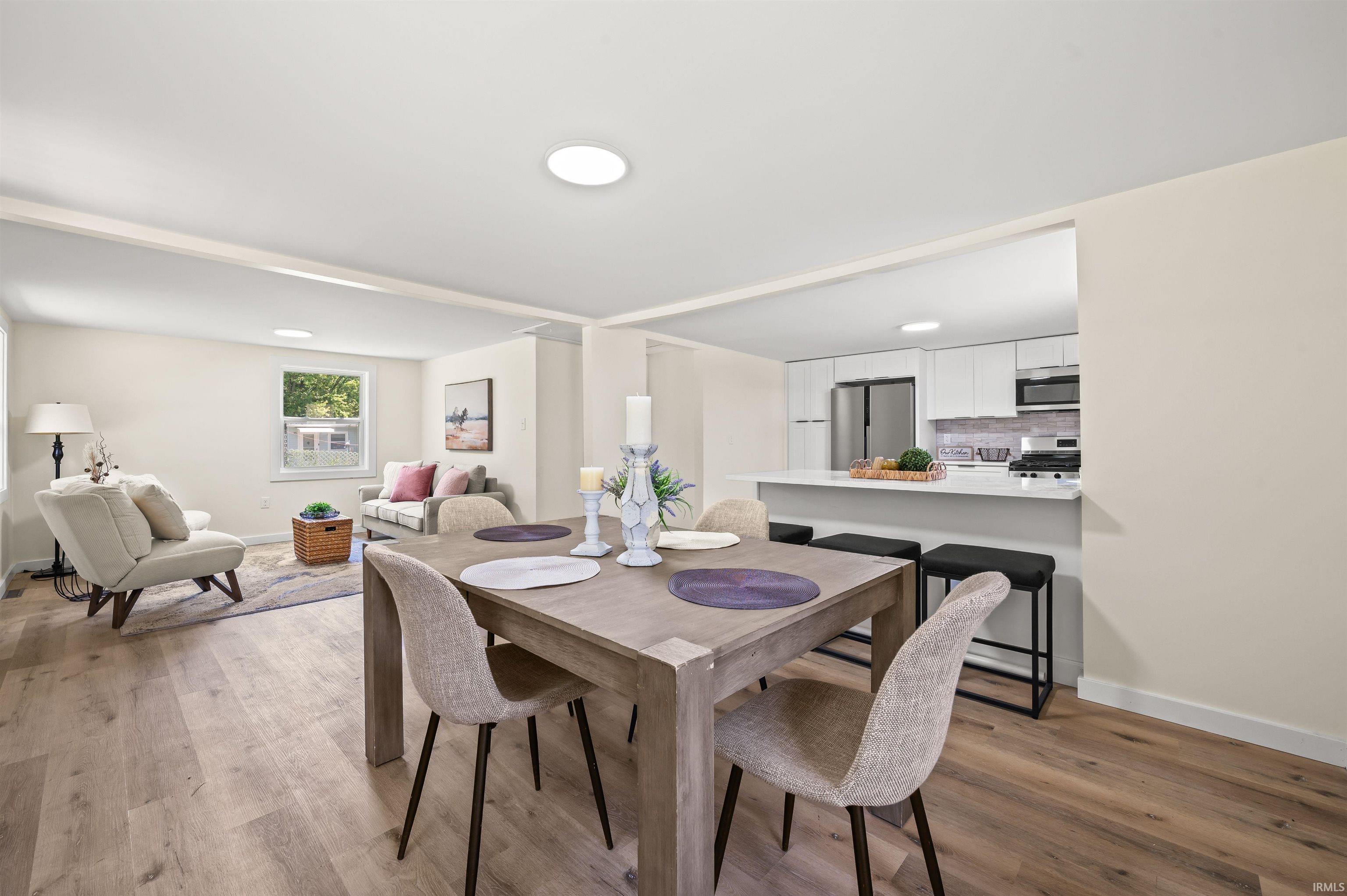 Open-concept living space featuring wood-finish flooring, recessed lighting, and neutral wall tones