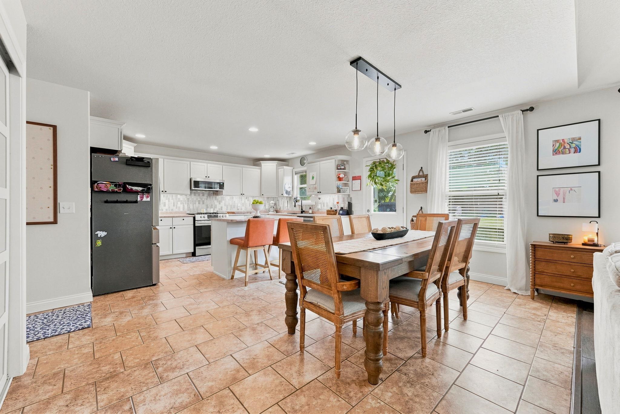 Open-concept kitchen and dining area featuring tile flooring