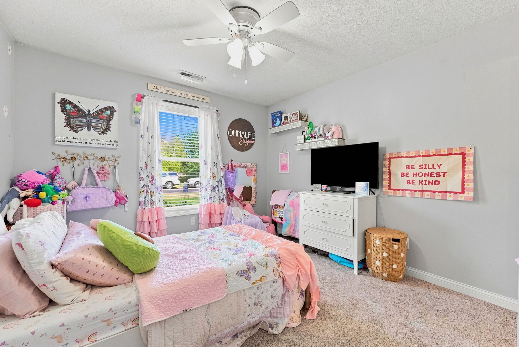 Bright room featuring brand new carpet, light gray walls and a ceiling fan