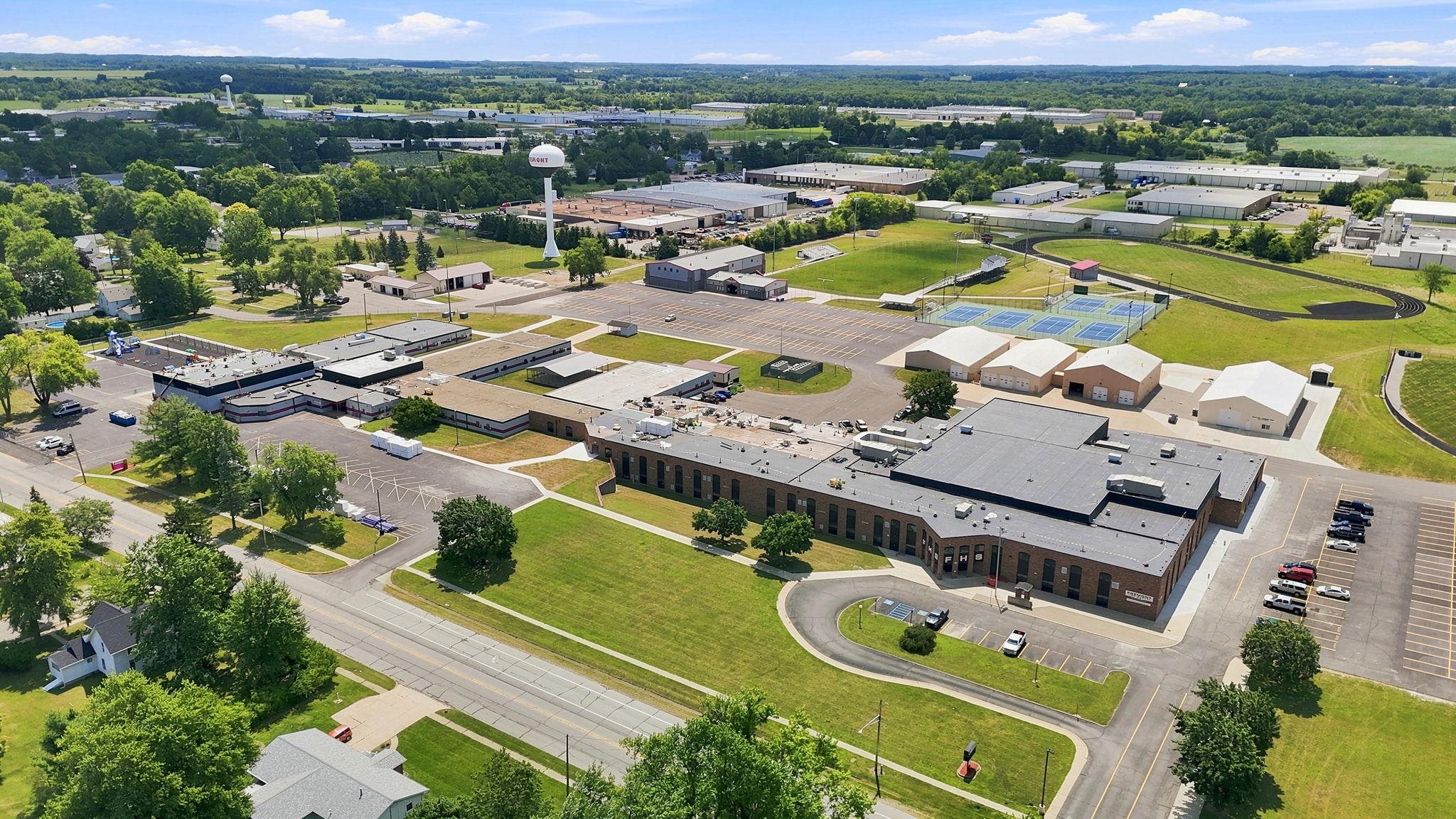 Extensive property featuring a large institutional building with multiple wings, abundant parking areas, green spaces, and athletic facilities including tennis courts and a running track  Fremont Schools are rated and are within 1 mile