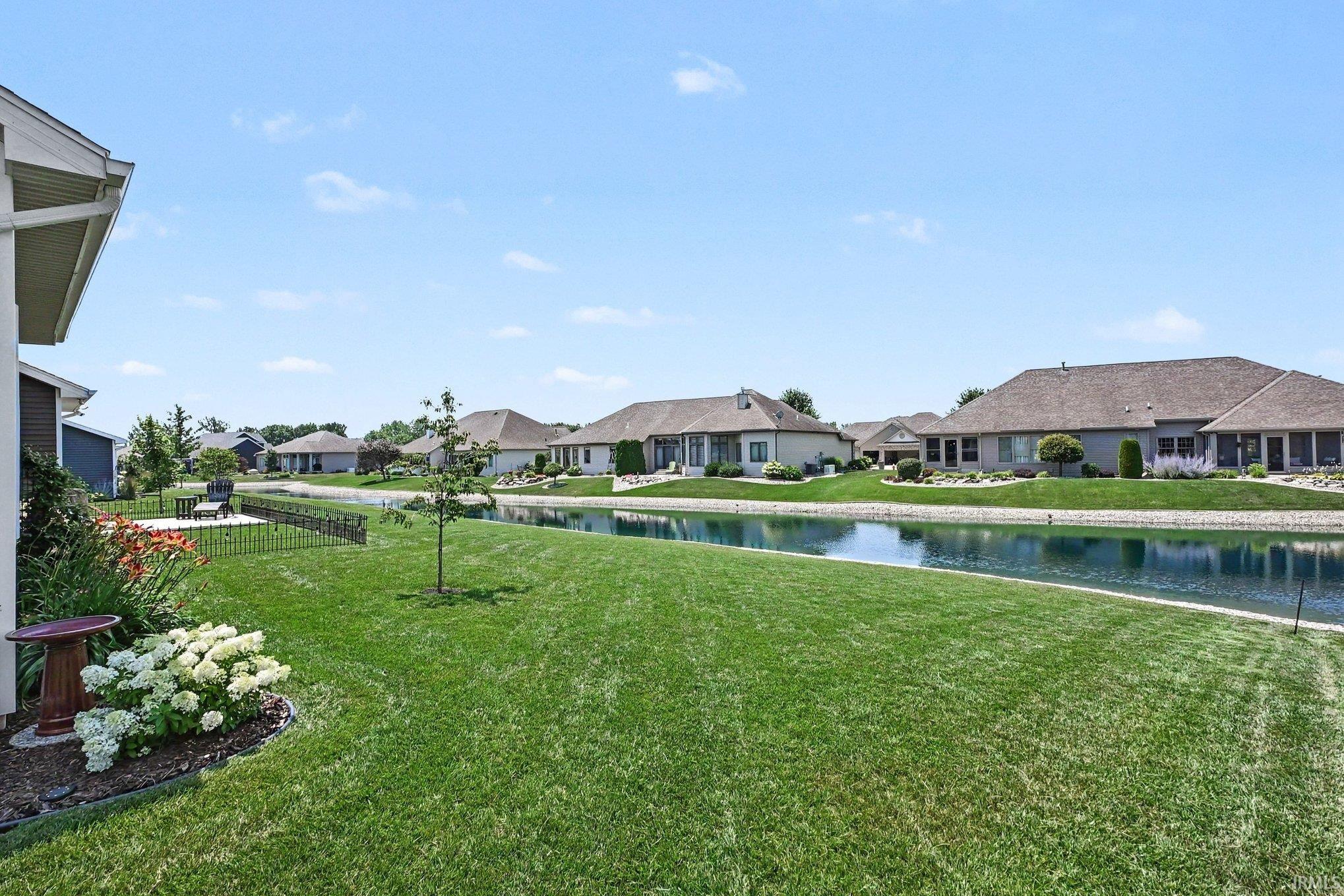 Expansive backyard featuring a manicured lawn, dedicated patio space, and mature landscaping