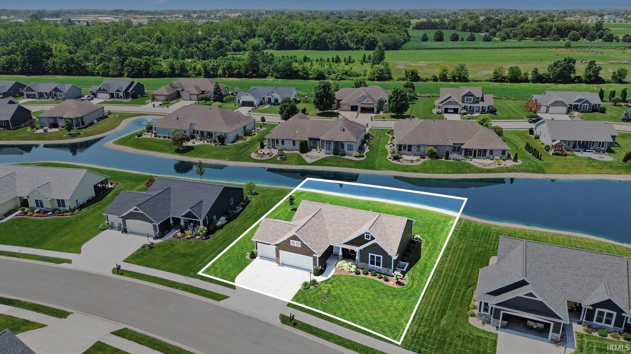 Modern single-story residence featuring a two-car garage, dark siding, and a light-toned roof