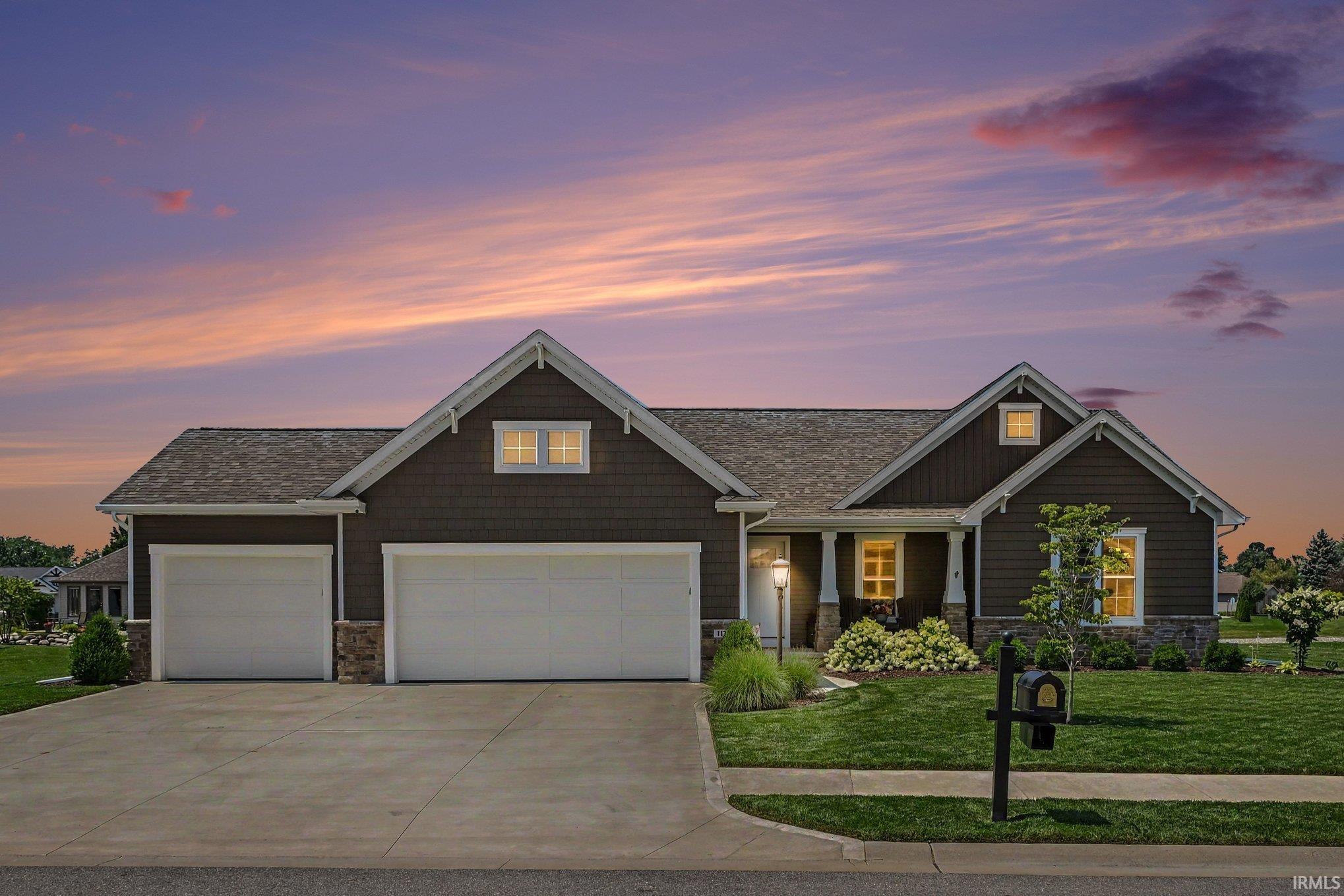 Contemporary ranch-style residence featuring a dark shingle roof and brown siding
