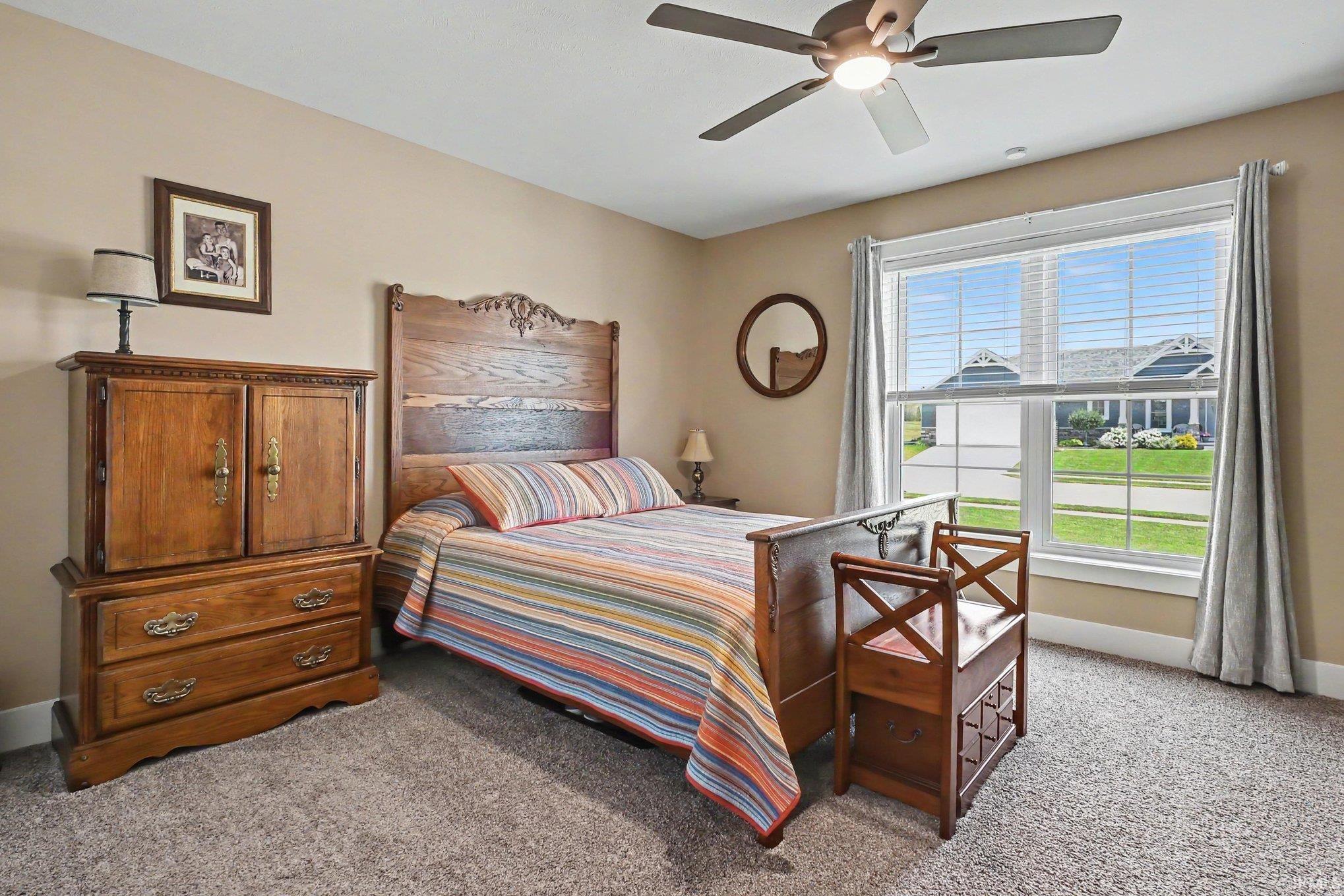 Bedroom featuring neutral wall paint, a ceiling fan with integrated lighting, and carpet flooring