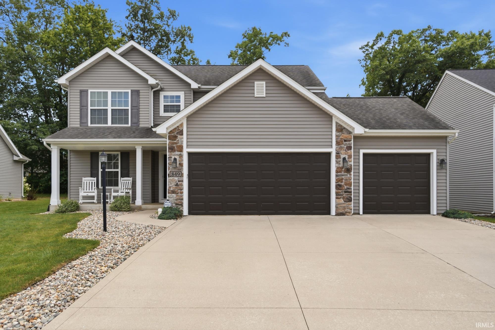 Contemporary residence featuring gray siding and stone accents