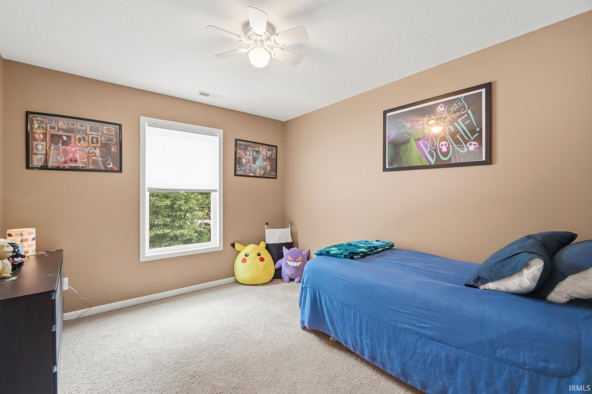 Neutral tone wall paint, light-toned carpeting, and a white ceiling fan with integrated lighting