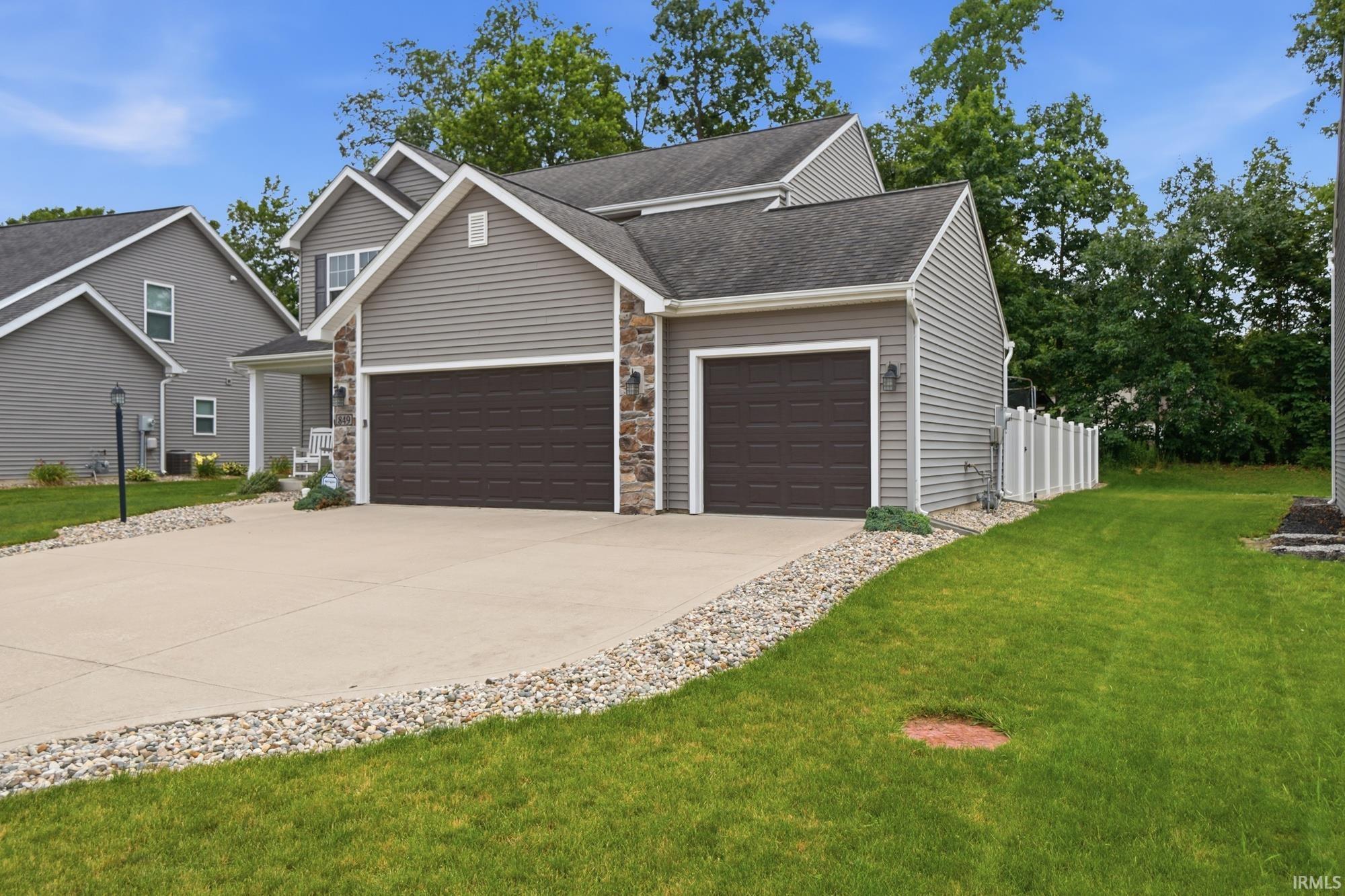Modern residential exterior with gray horizontal siding and stone veneer accents