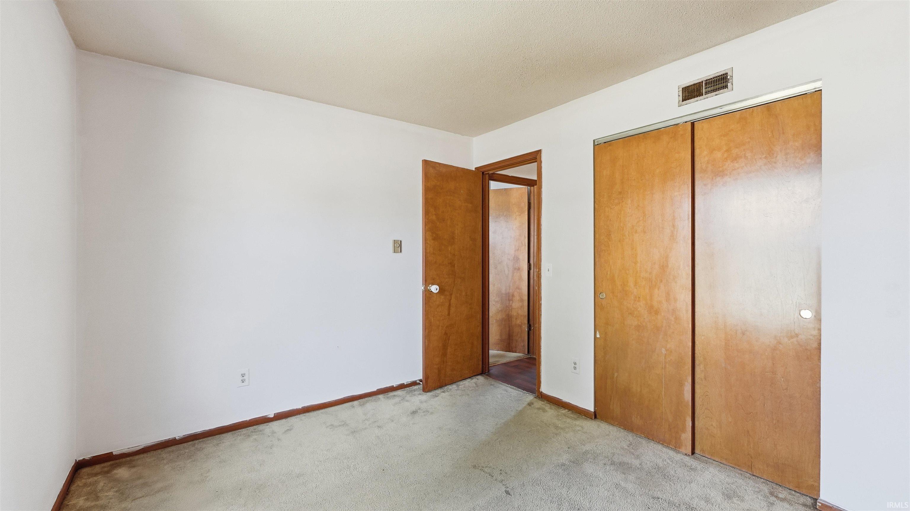 Room featuring white painted walls and light-colored carpet flooring