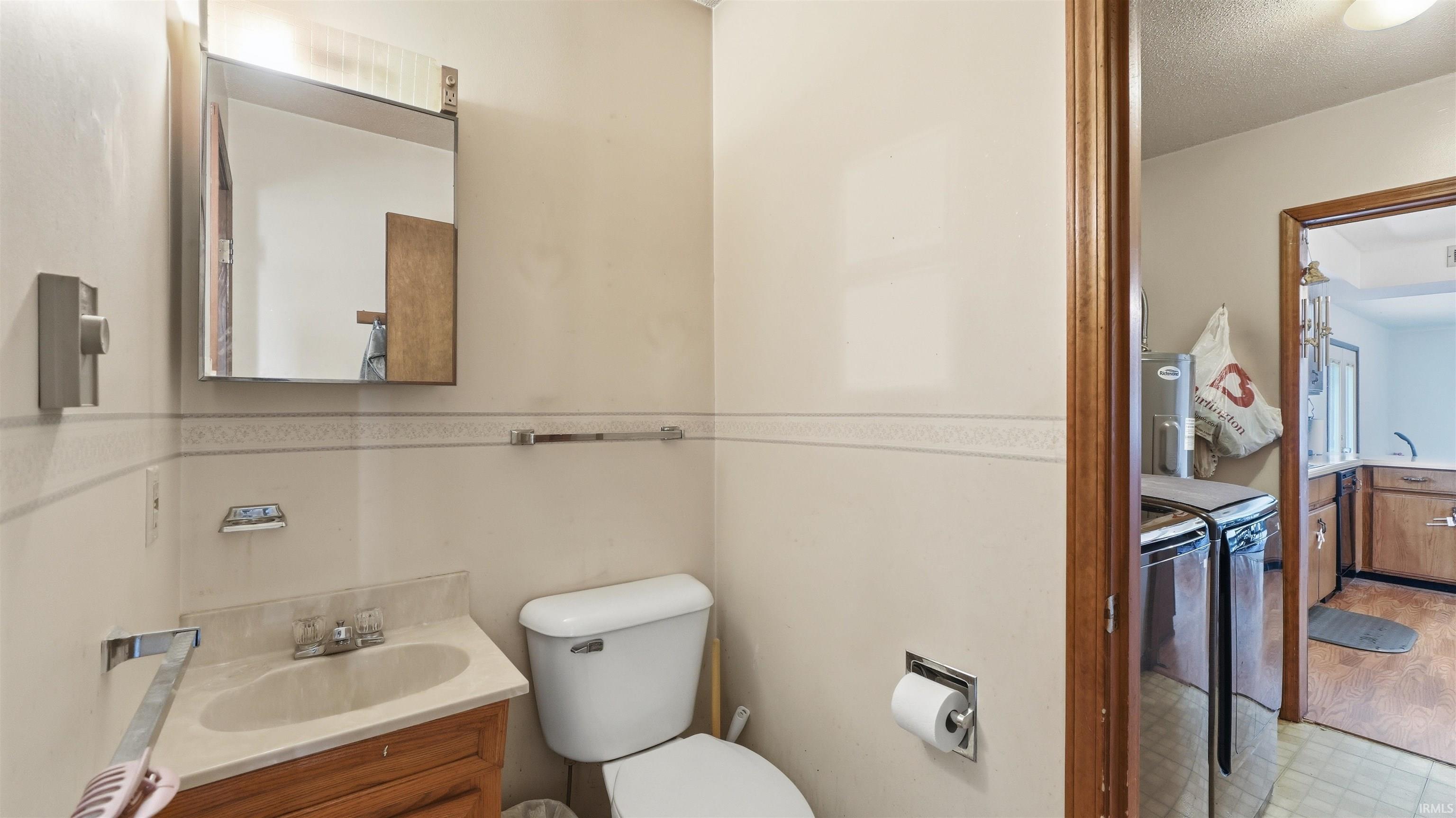Bathroom featuring a wood-finish vanity with an integrated sink and a wall-mounted medicine cabinet