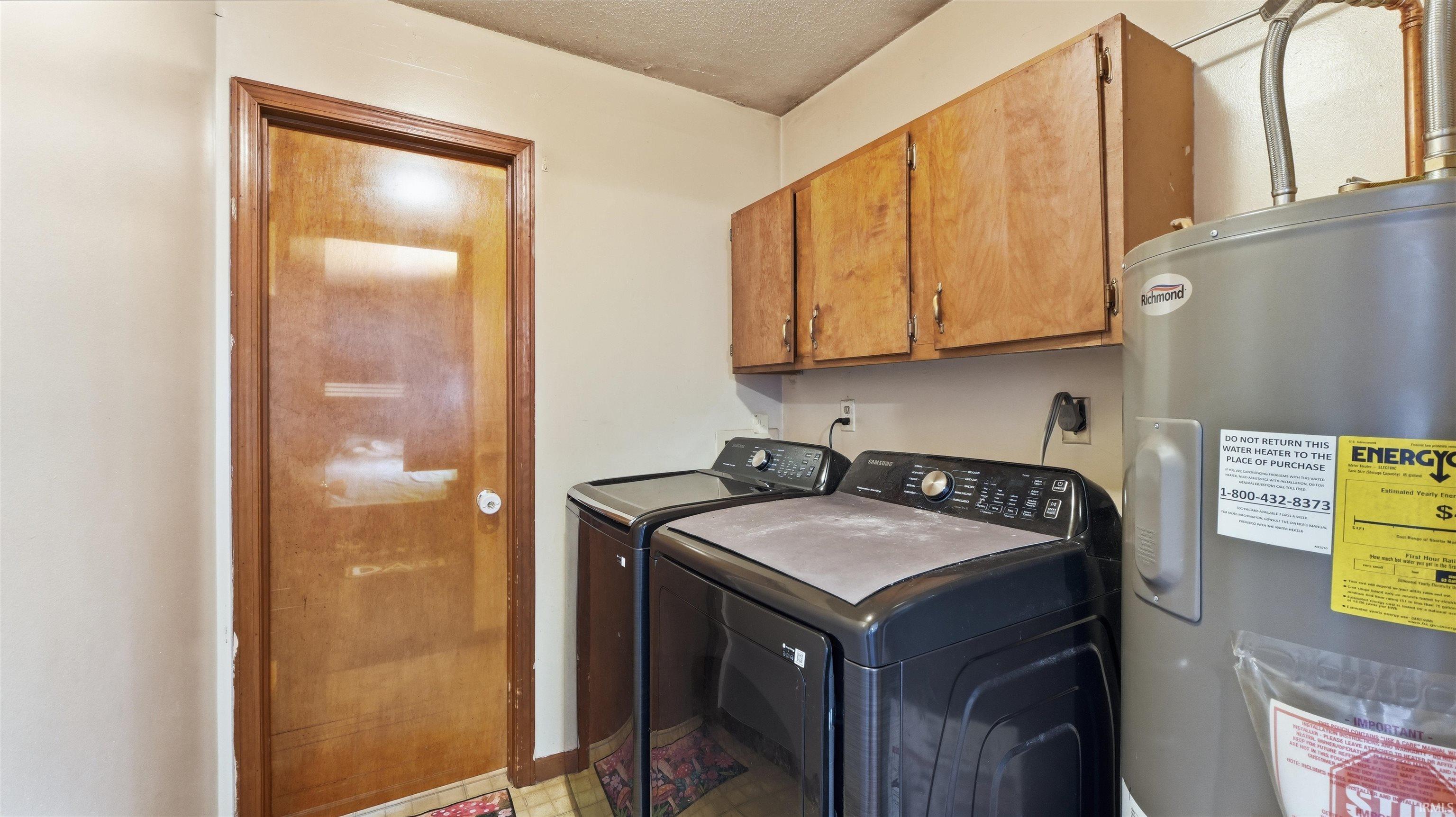 Utility area featuring an installed water heater, wood-finish cabinetry, and a wood-finish door with white hardware