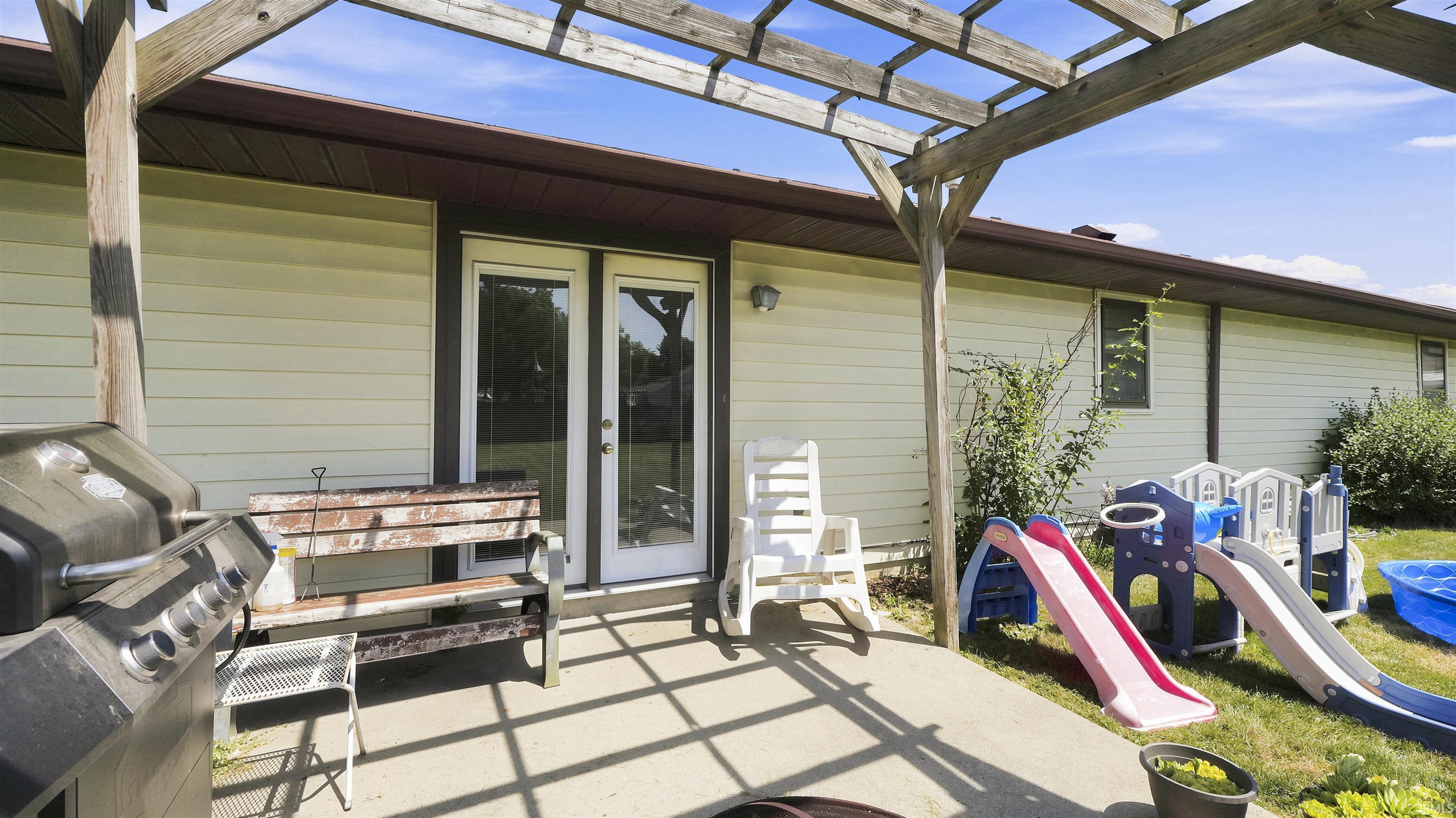 Concrete patio with a wooden pergola structure