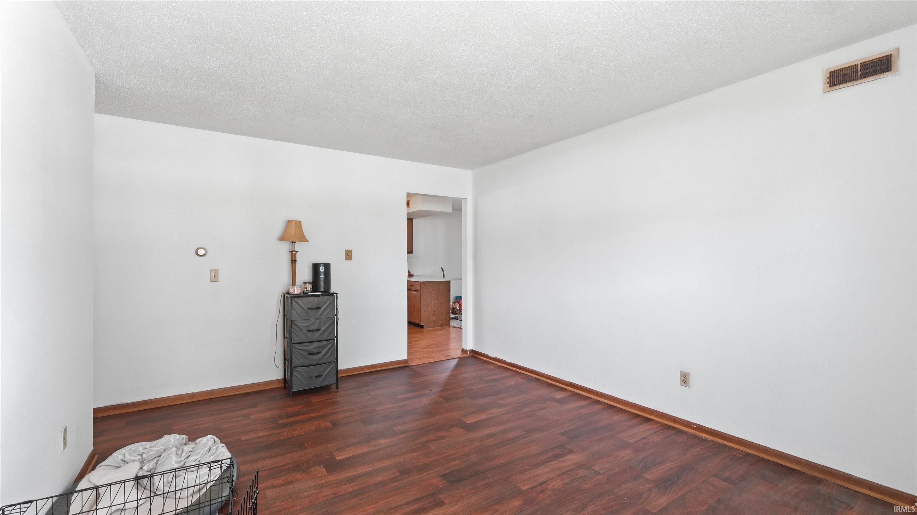 Living area featuring rich wood-finish flooring, white walls, and white trim