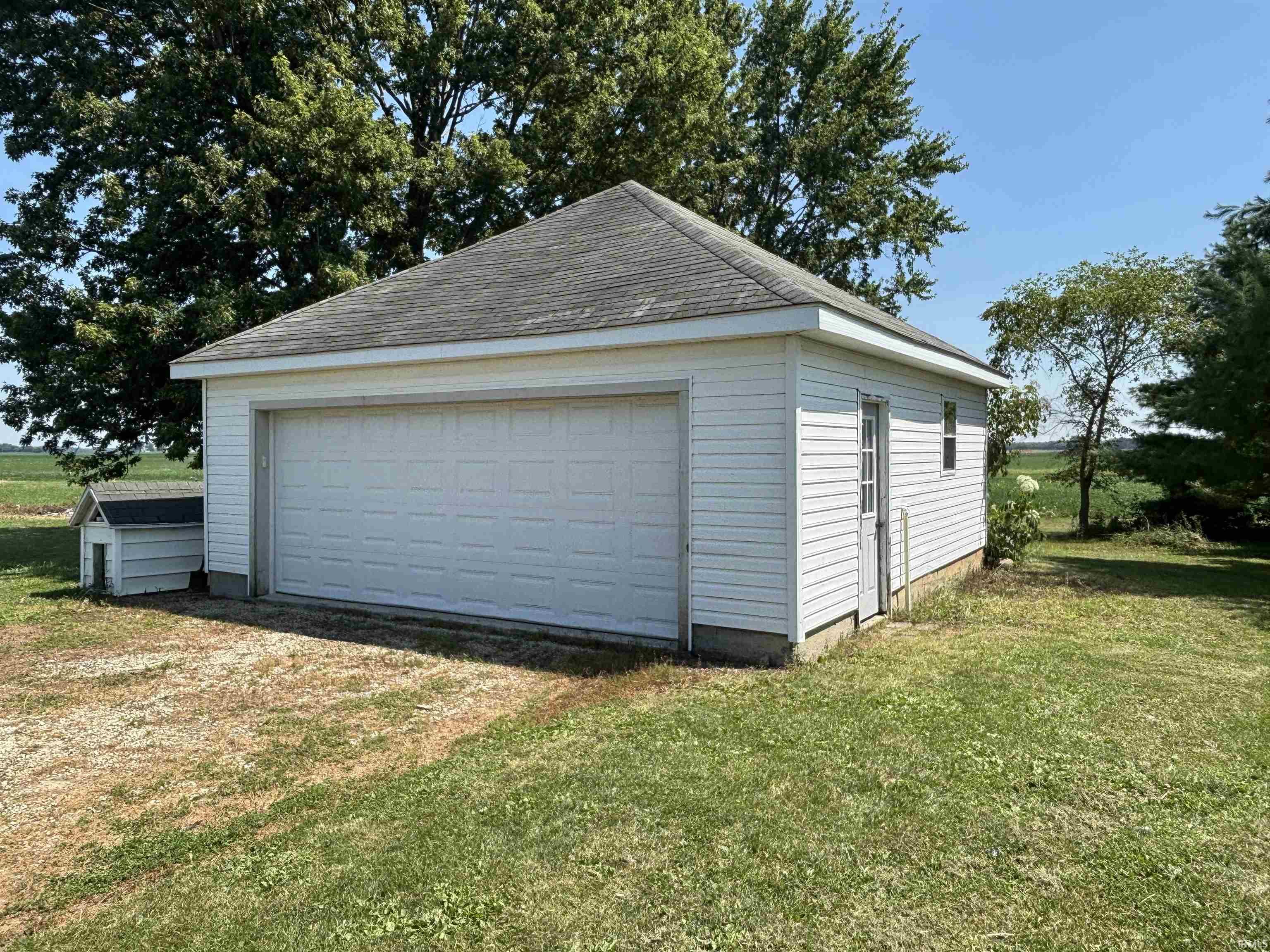 Detached two-car garage with white siding and a gray shingle roof