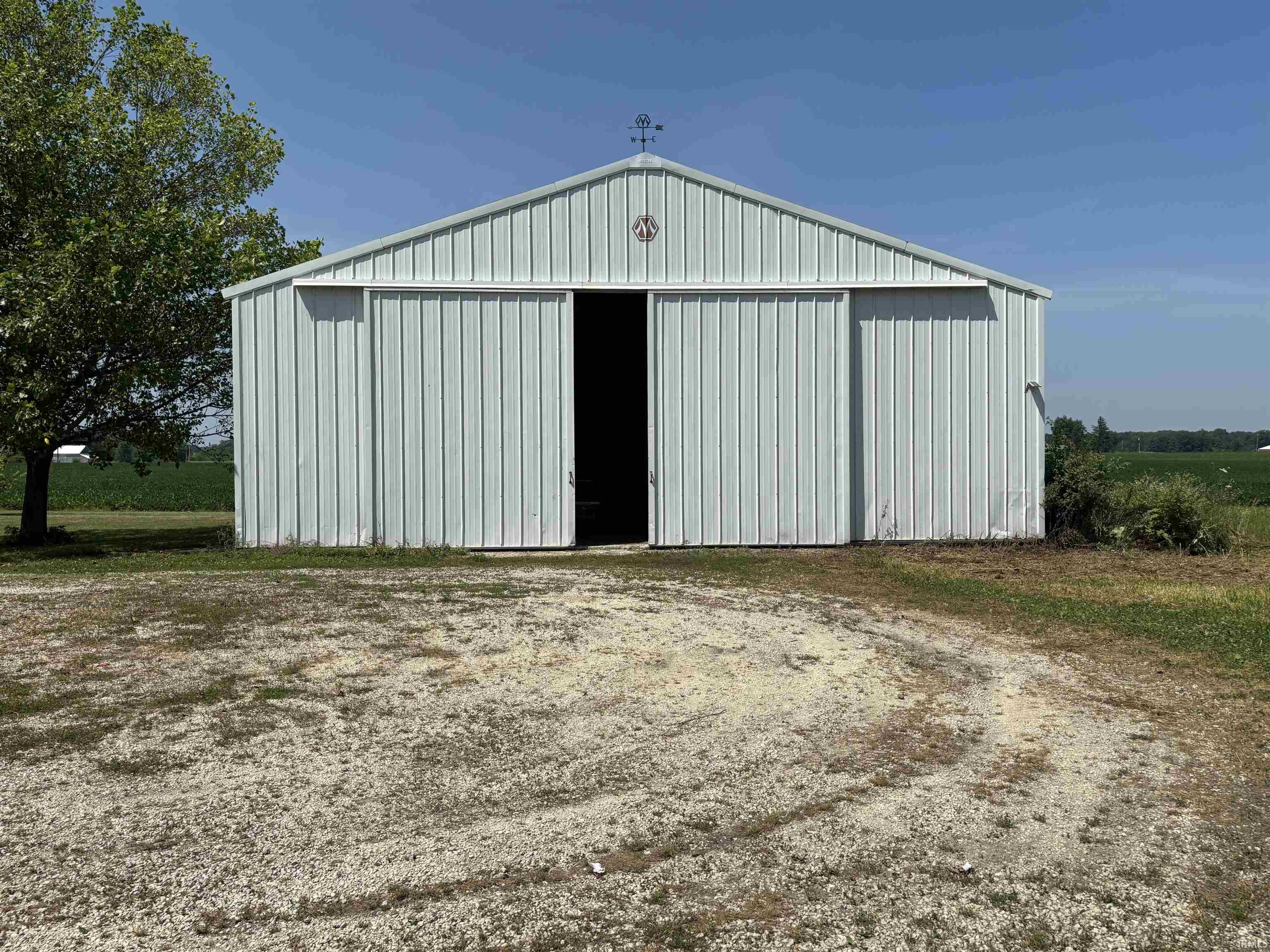 Metal-sided outbuilding featuring a pitched roof and a weather vane accent